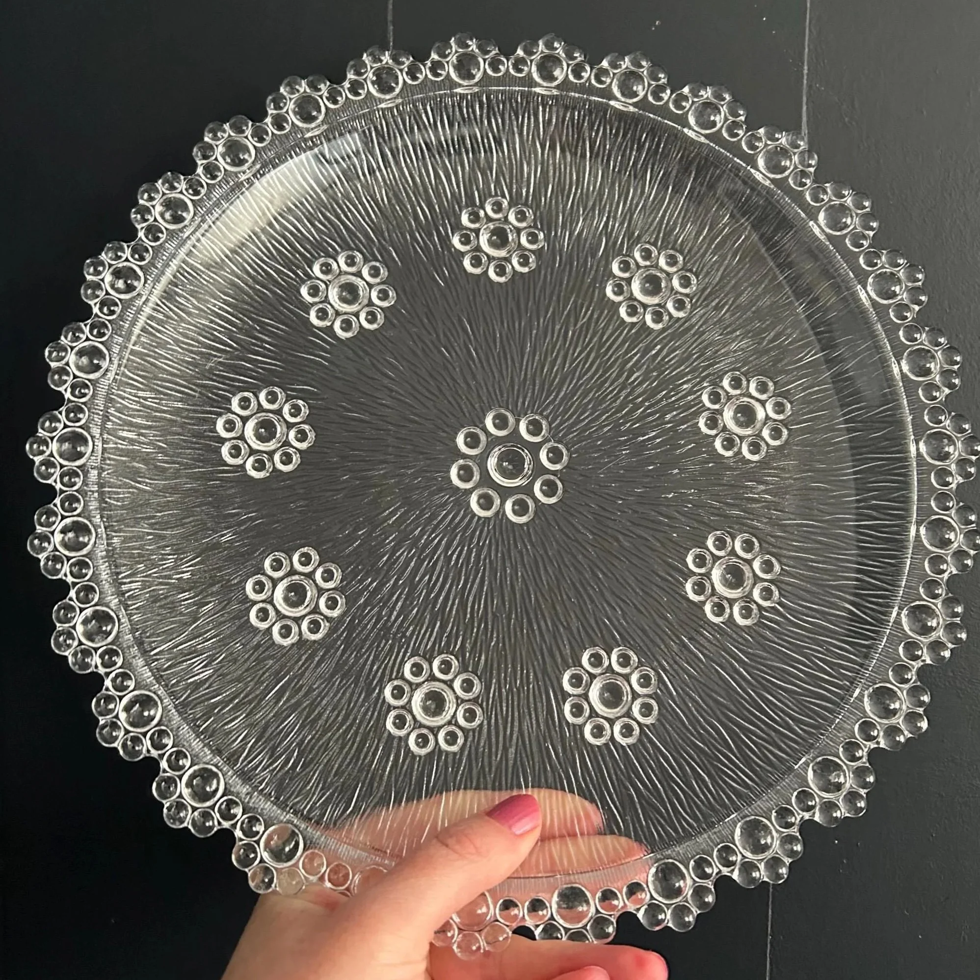 Full view of the Masserini Barocco round glass platter showing textured surface and bubble edge