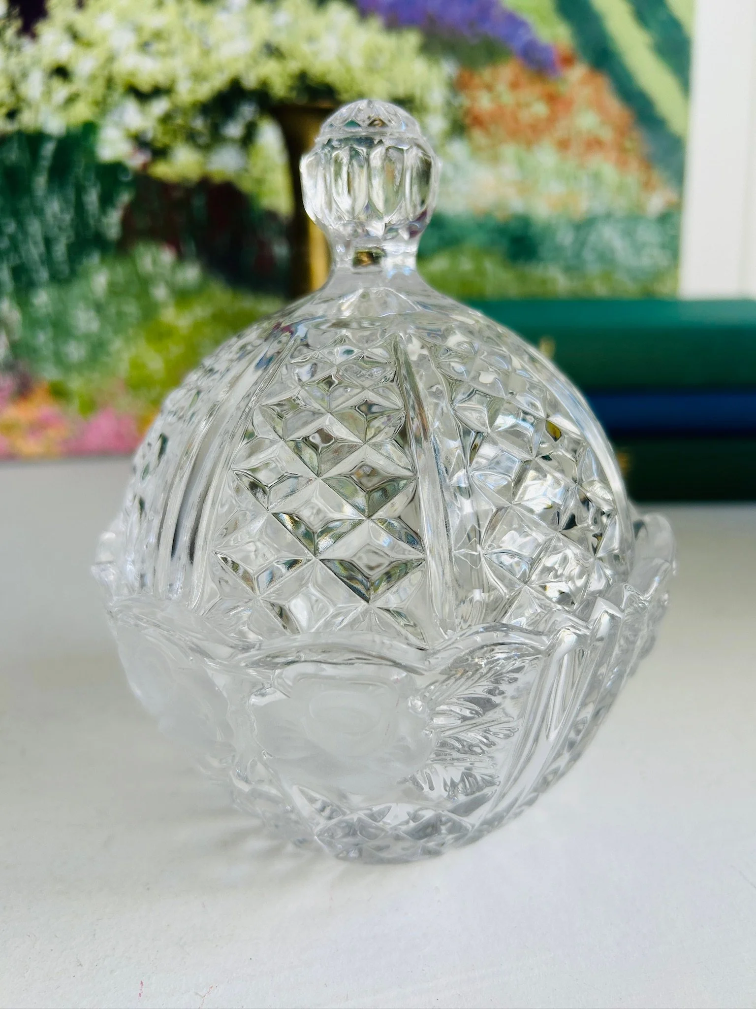 Front view of vintage Anna Hütte Bleikristall lidded candy dish in clear 24% lead crystal, showing its rounded shape, faceted finial, and frosted rose detail.