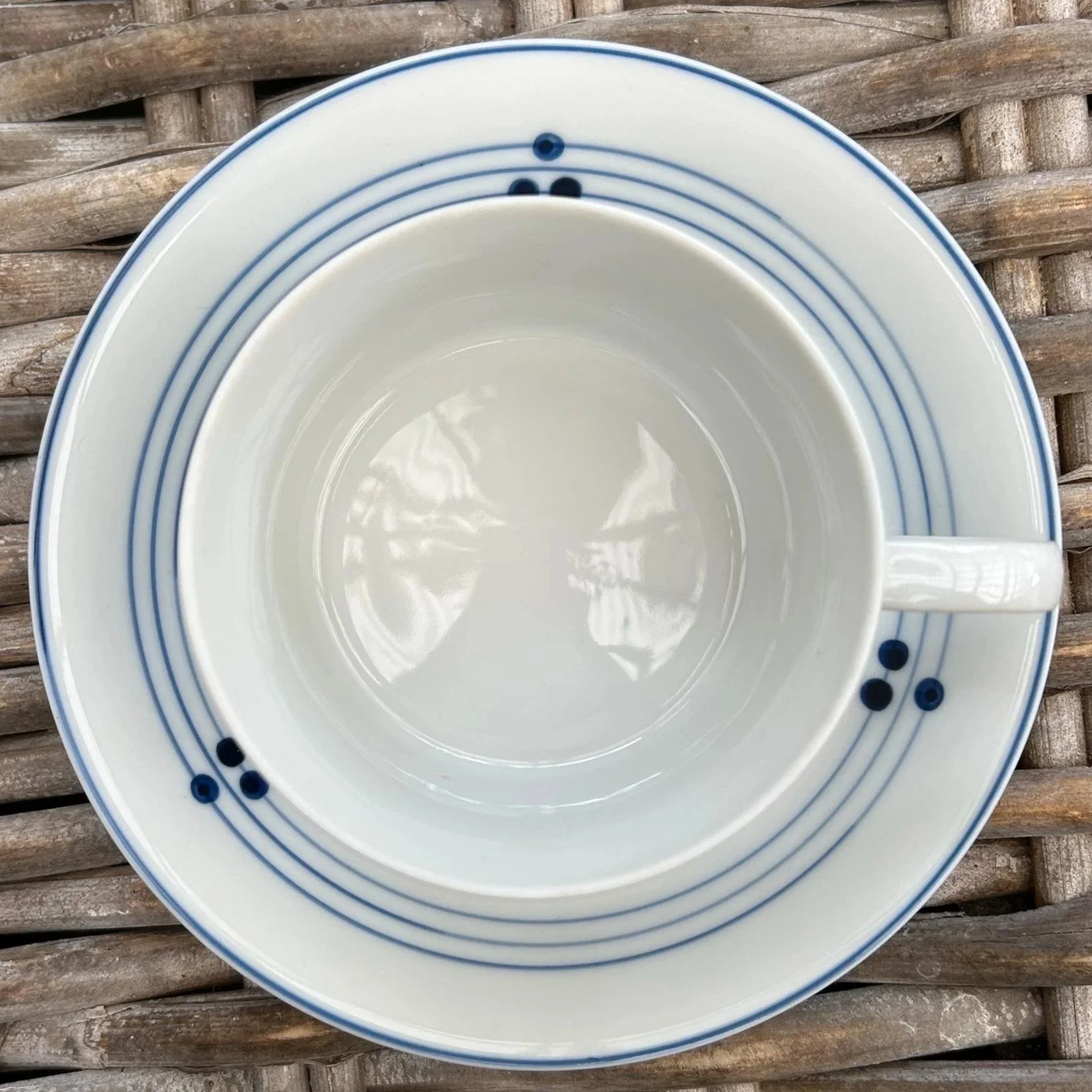 Top-down view of cup and saucer – blue pinstripe and dot detailing shown