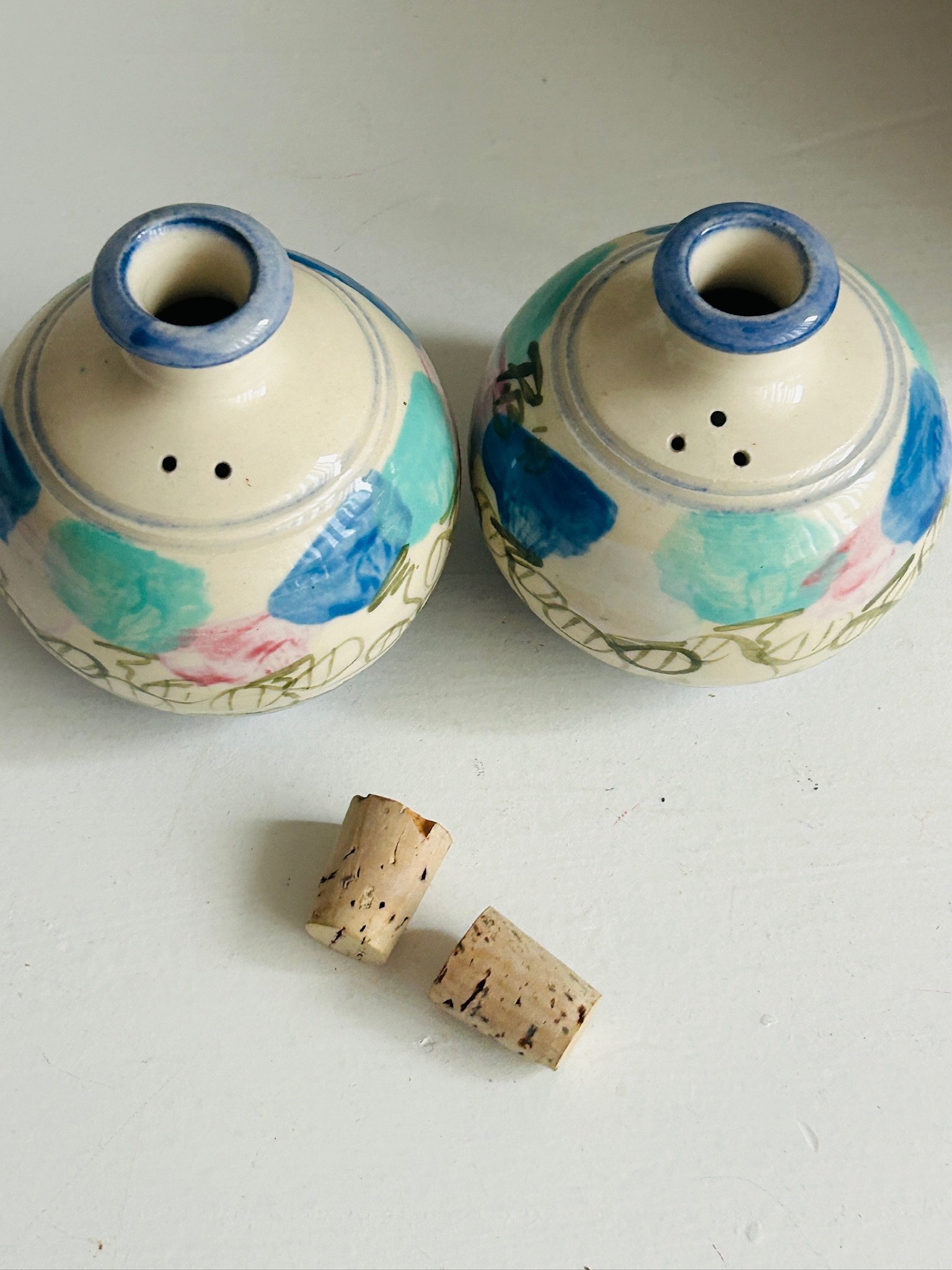 Top view of both shakers with cork stoppers removed, showing shaker holes and hand-painted decoration