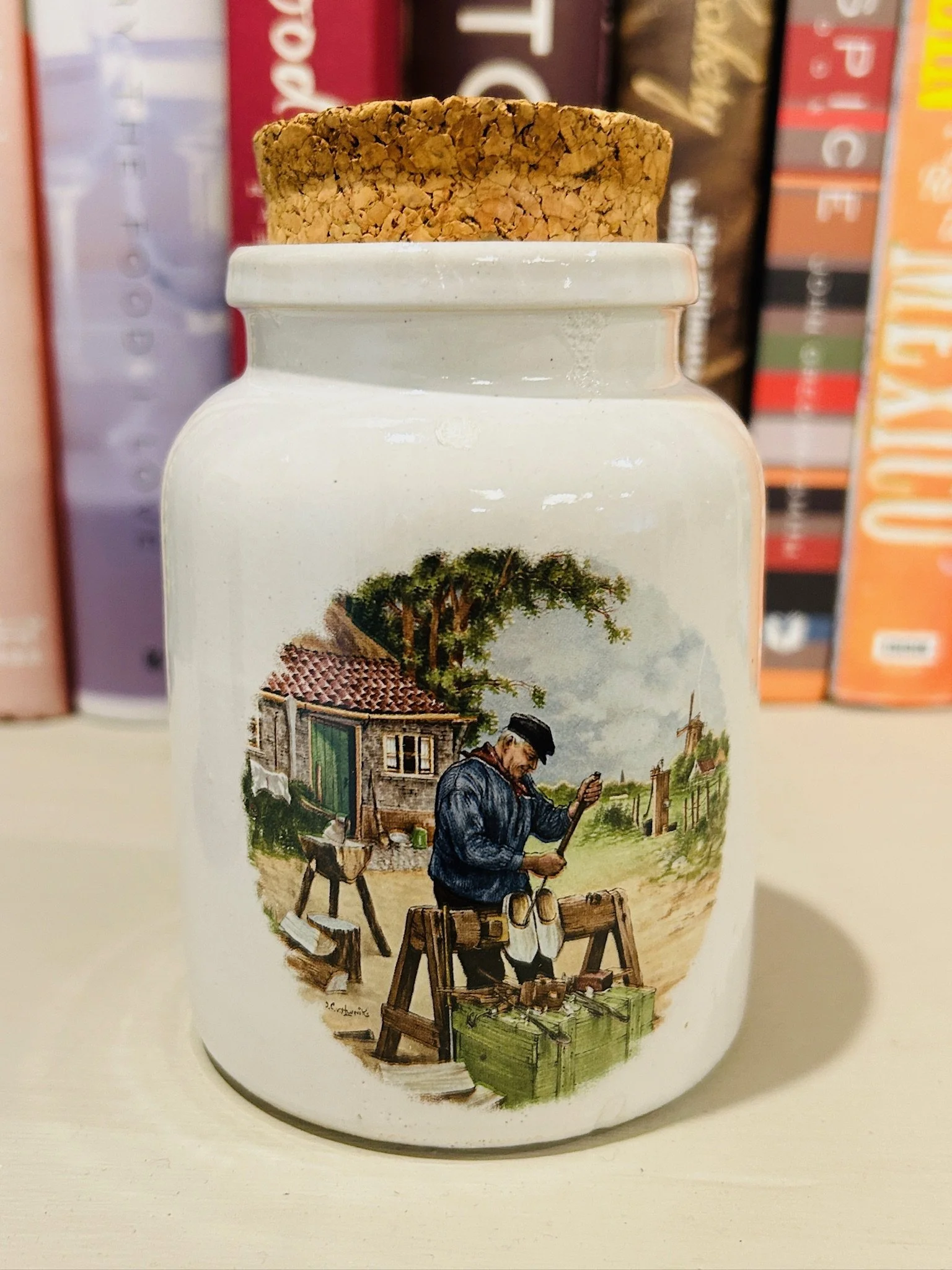 Close-up of the cobbler scene on one pot, highlighting the artisan brushwork and rustic village details.