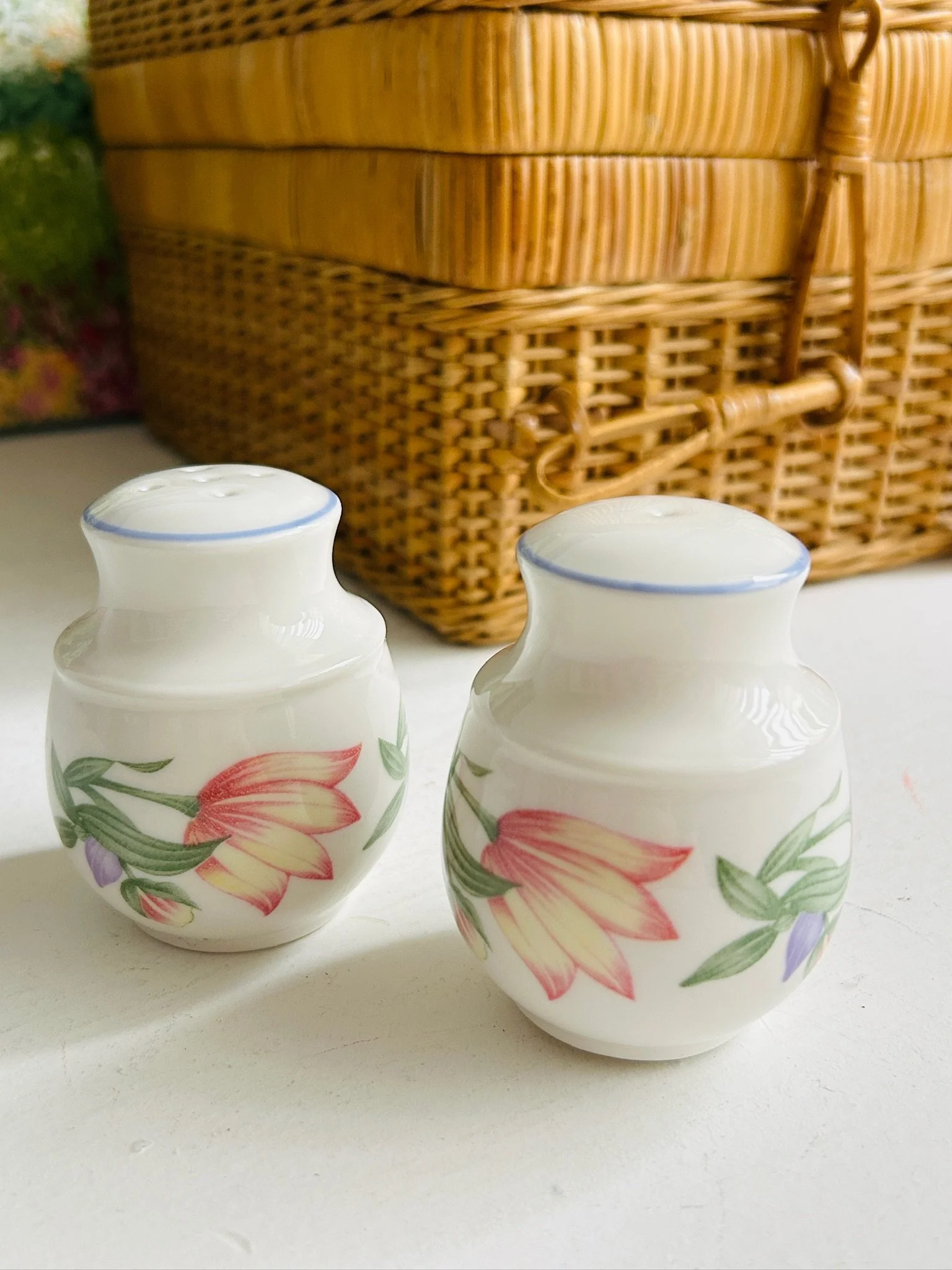 Front view of the pair standing upright with floral decoration visible on both shakers