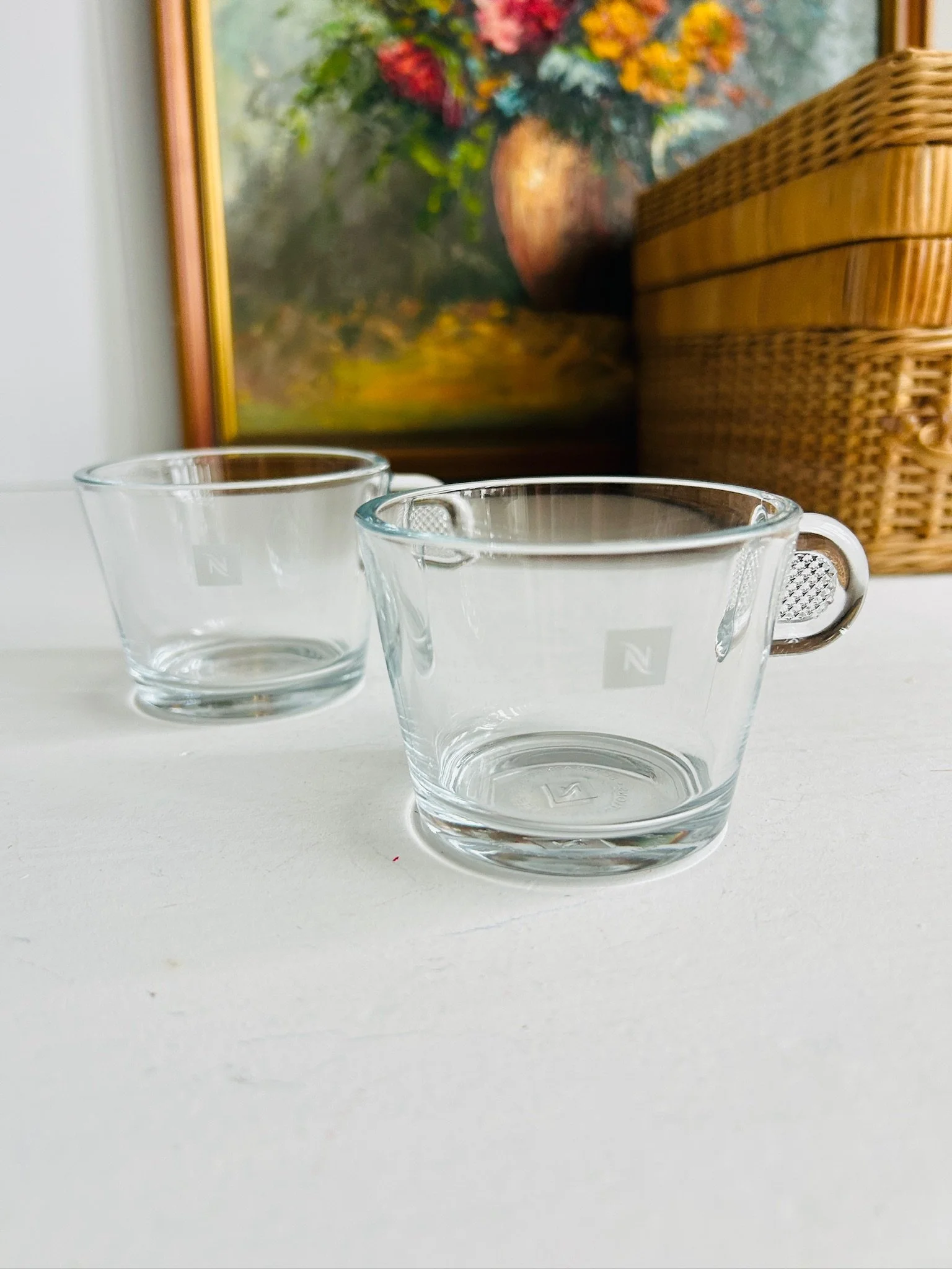 Pair of clear glass Nespresso espresso cups displayed side by side on a white surface
