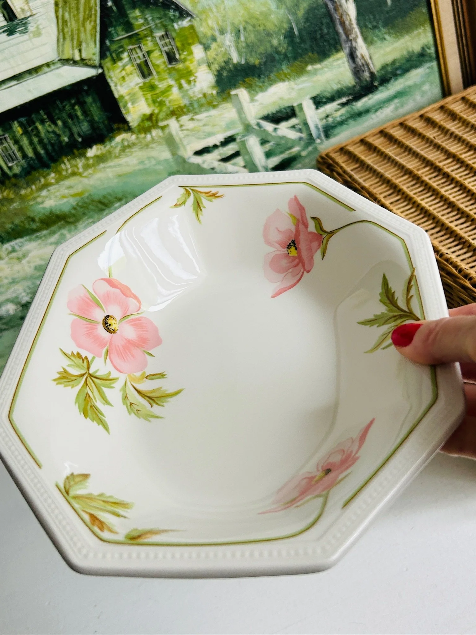 Single octagonal serving bowl held in hand, showing the overall size, shape, and pink floral design.