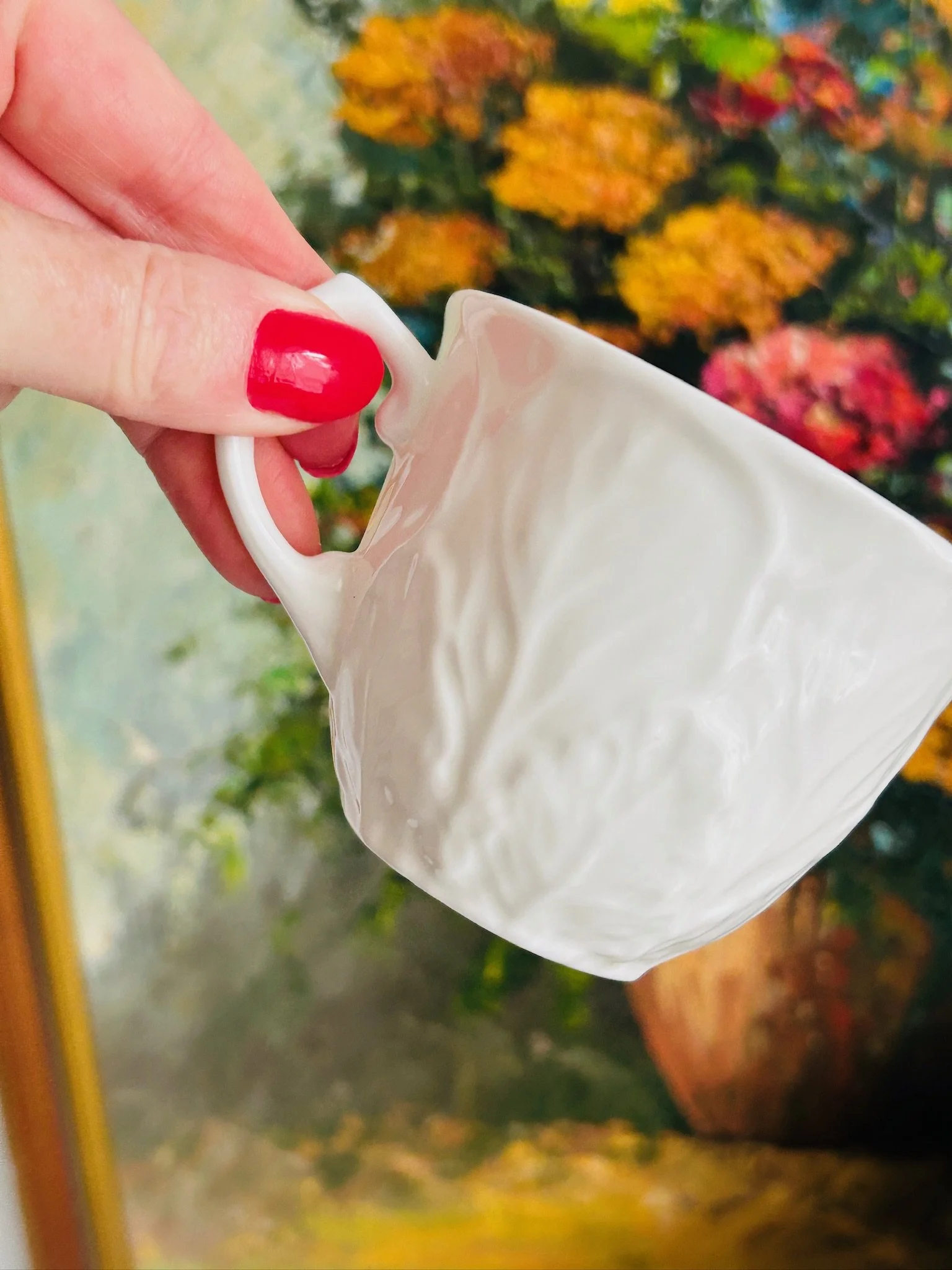 Detail of the saucer rim showing the embossed rose pattern and scalloped border in white porcelain.