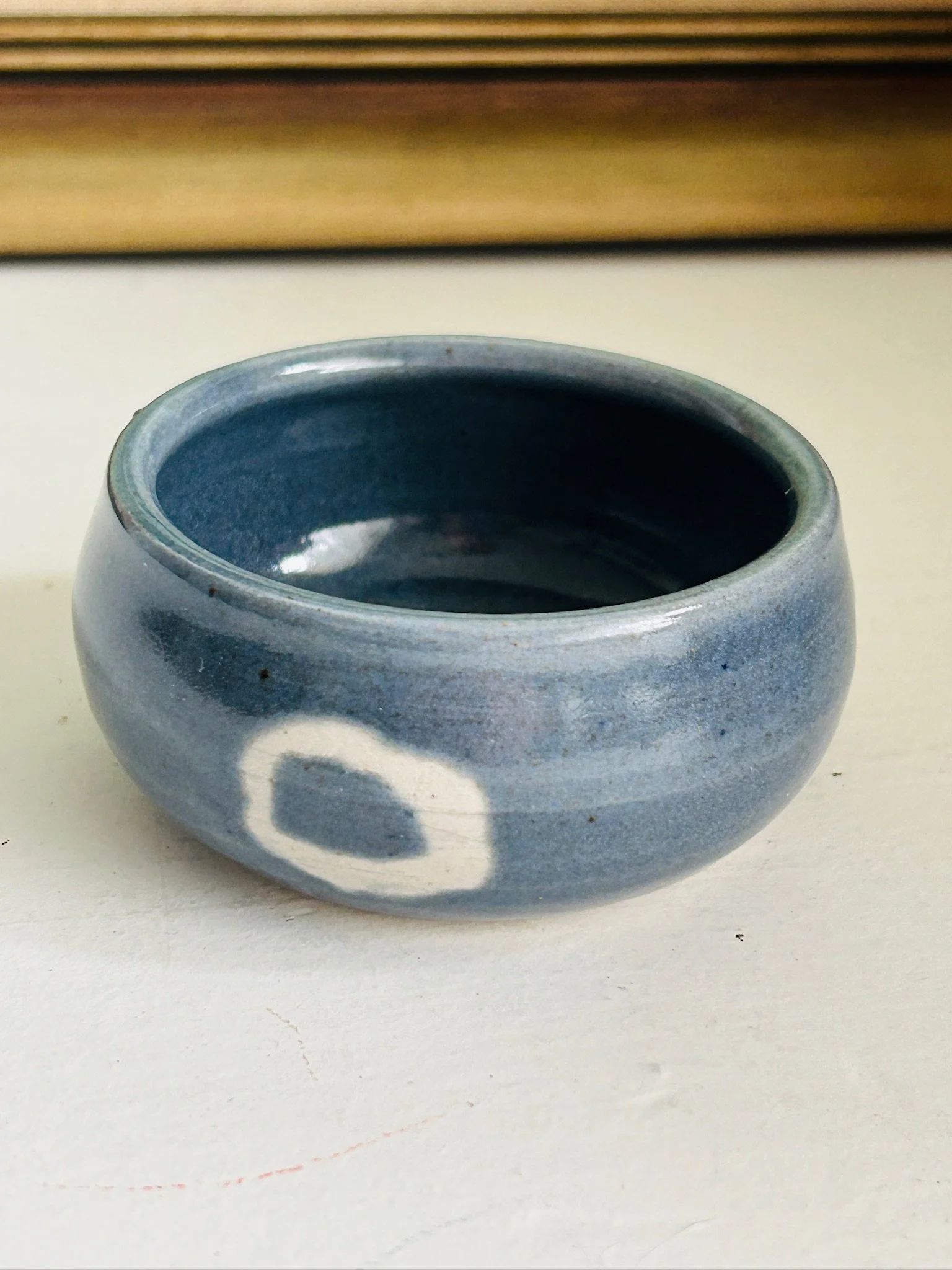 Front view of a small D Matthews studio pottery bowl with smoky blue-grey glaze and white ring motif near the base