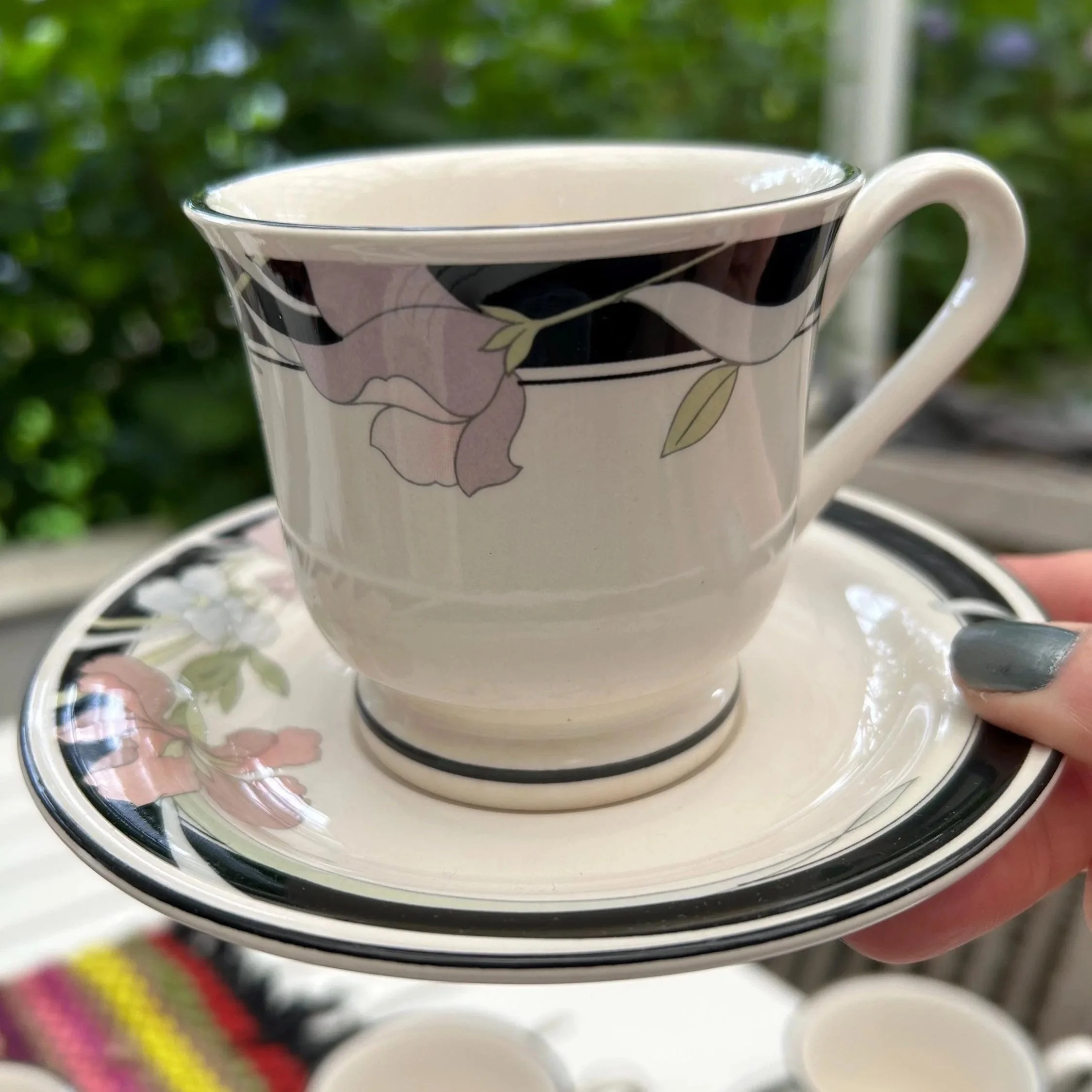 Front angle view of a cup on its matching saucer, floral motif clearly visible