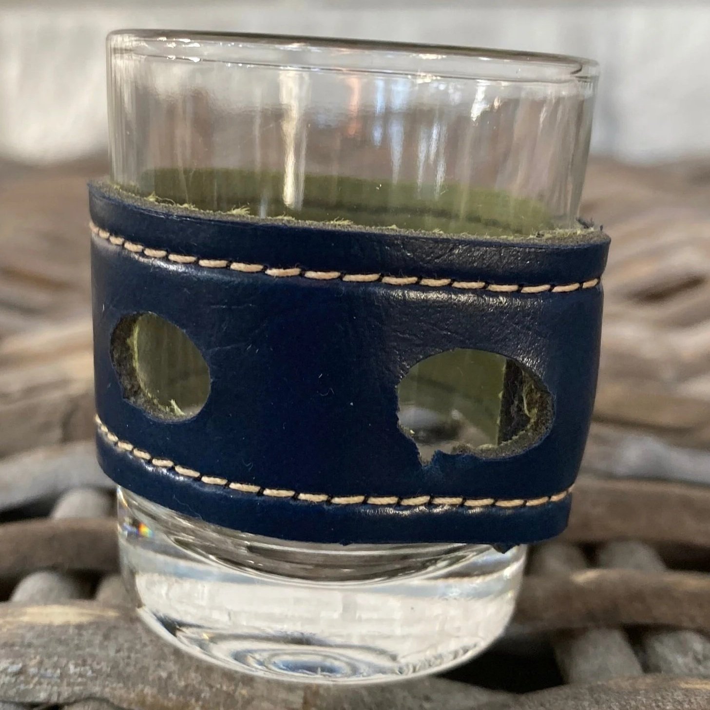 Close-up of navy leather band with stitched edges and circular cut-outs