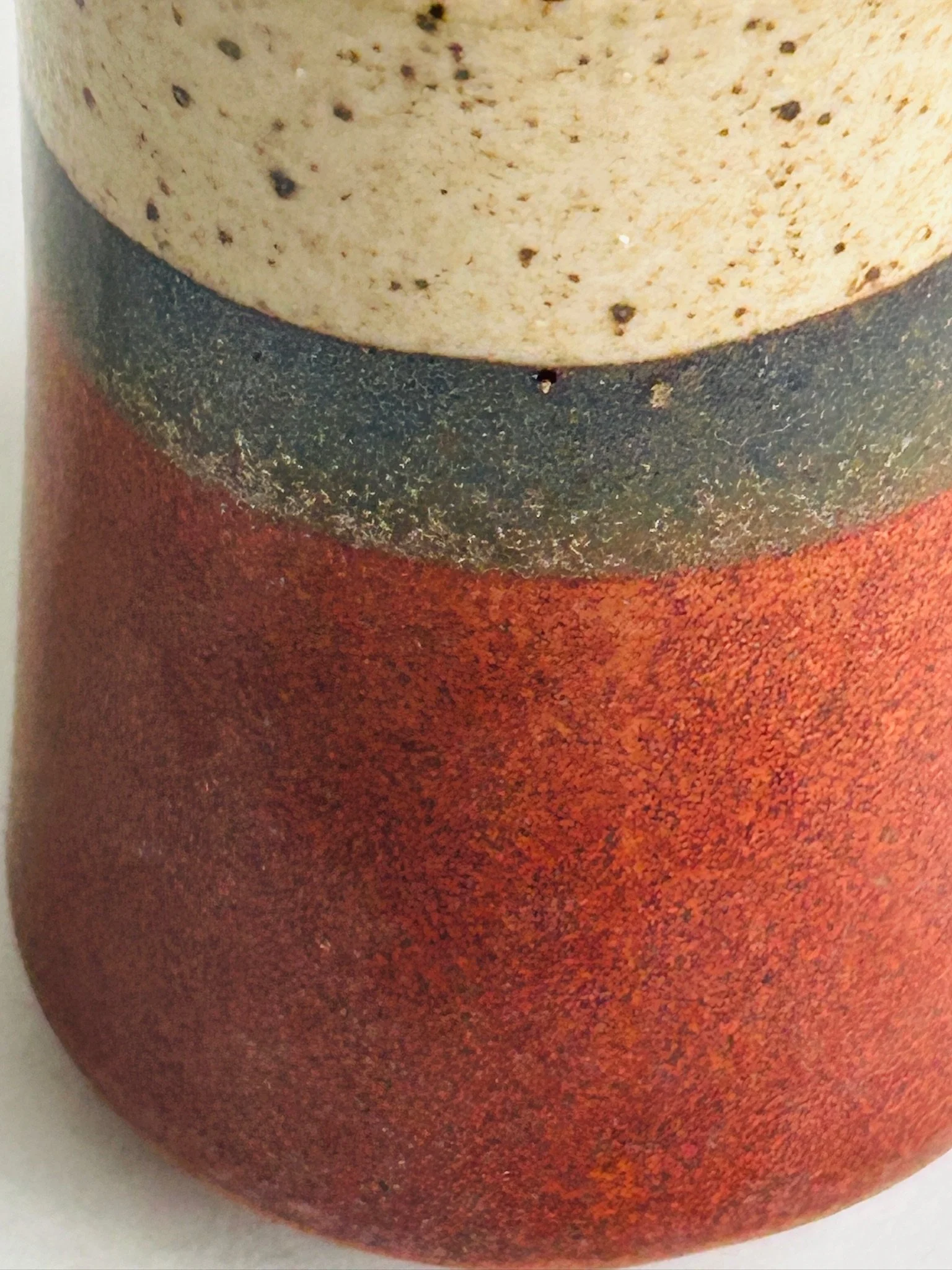 Close-up of one shaker top showing the speckled cream glaze and dispensing holes.