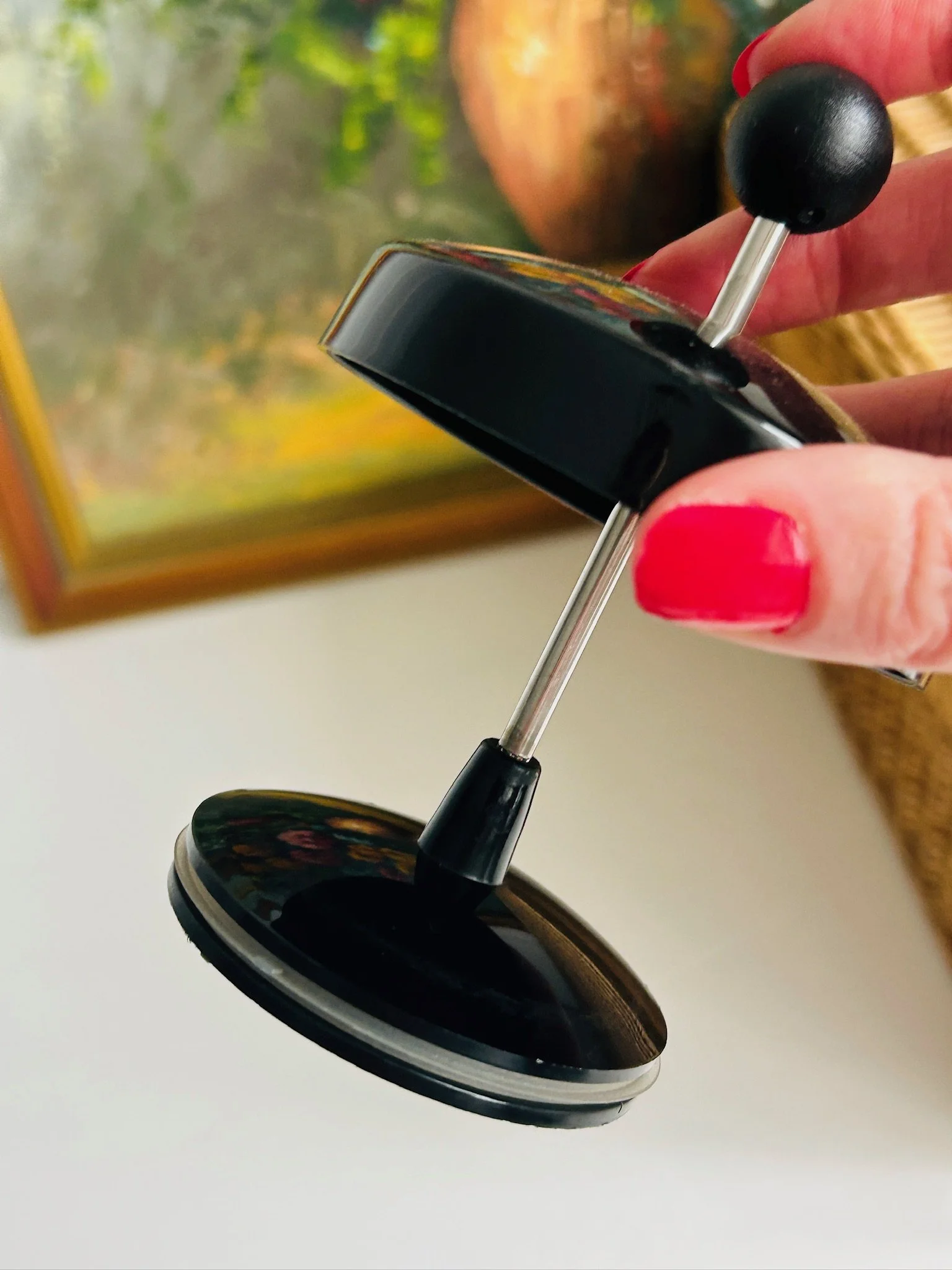 Close-up of the Bodum Assam plunger lid and metal press rod, showing the black knob and internal press mechanism.