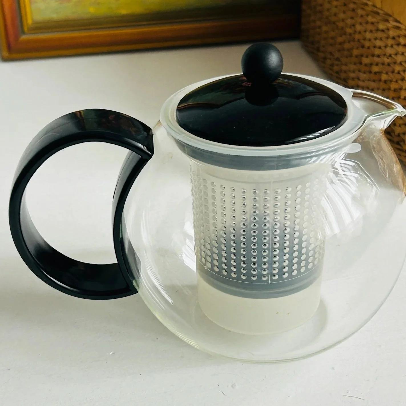 Detailed close-up of the perforated infuser mesh inside the clear glass body.
