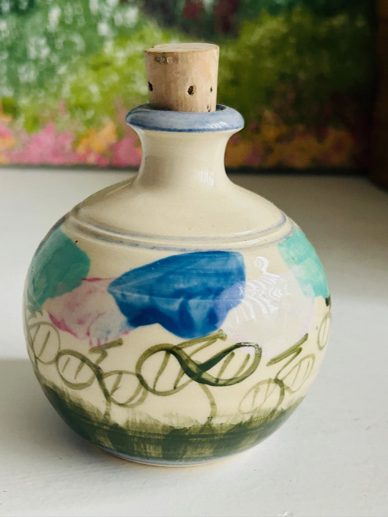 Side view of shaker highlighting cream glaze, painterly pink and blue decoration, and rounded bulb form