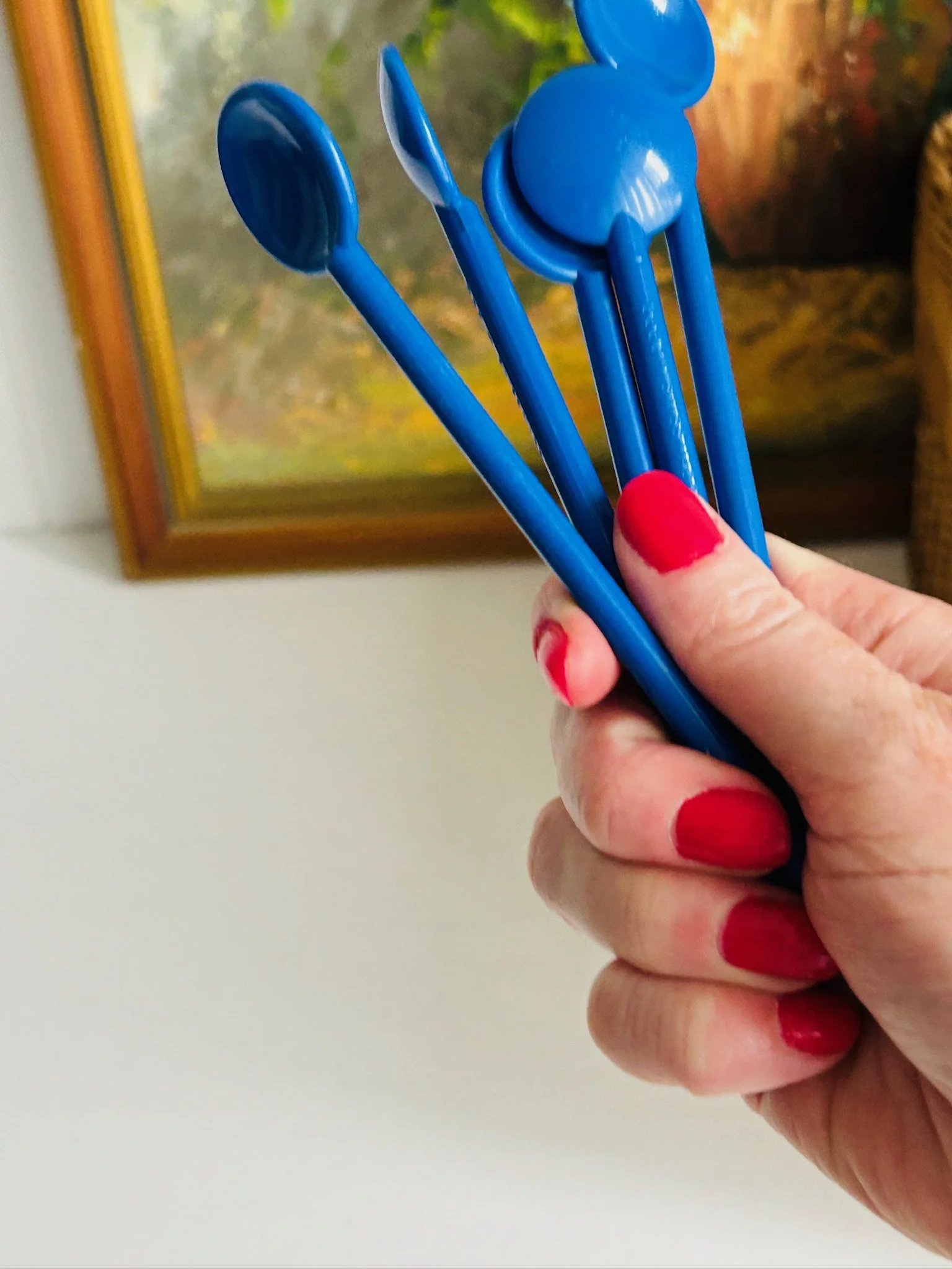 Group of Bodum blue stir spoons held together in hand, showing the set and matching shape