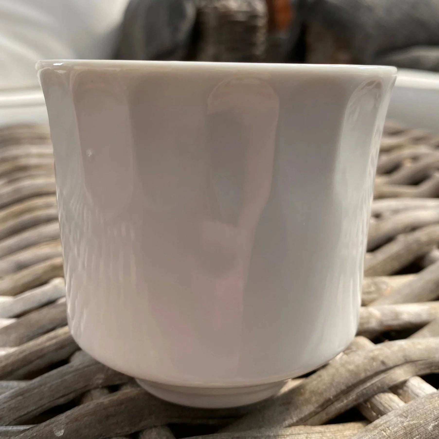 Side view of plain white glazed ribbed ceramic cup