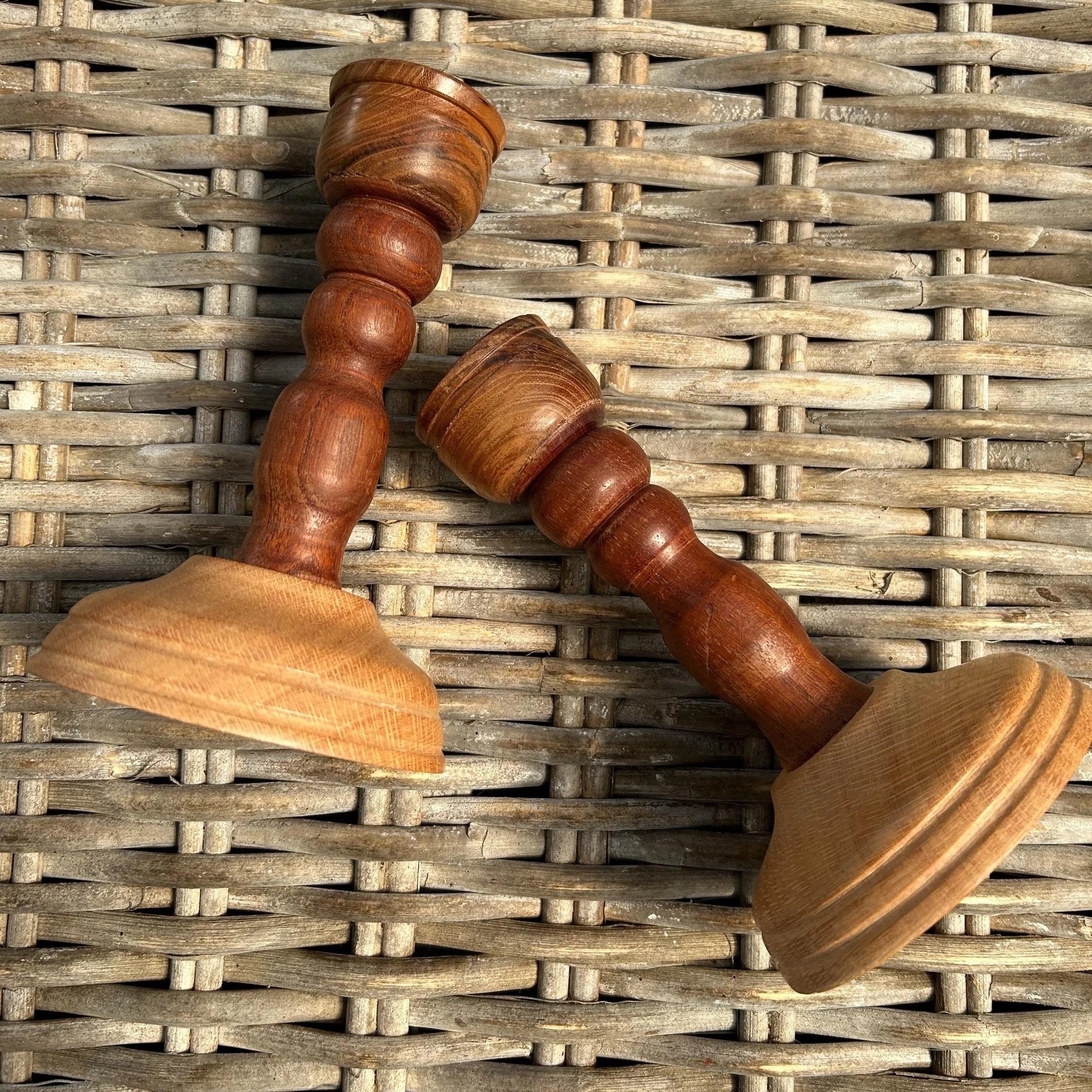 Both candleholders lying on rattan surface, showing full shape