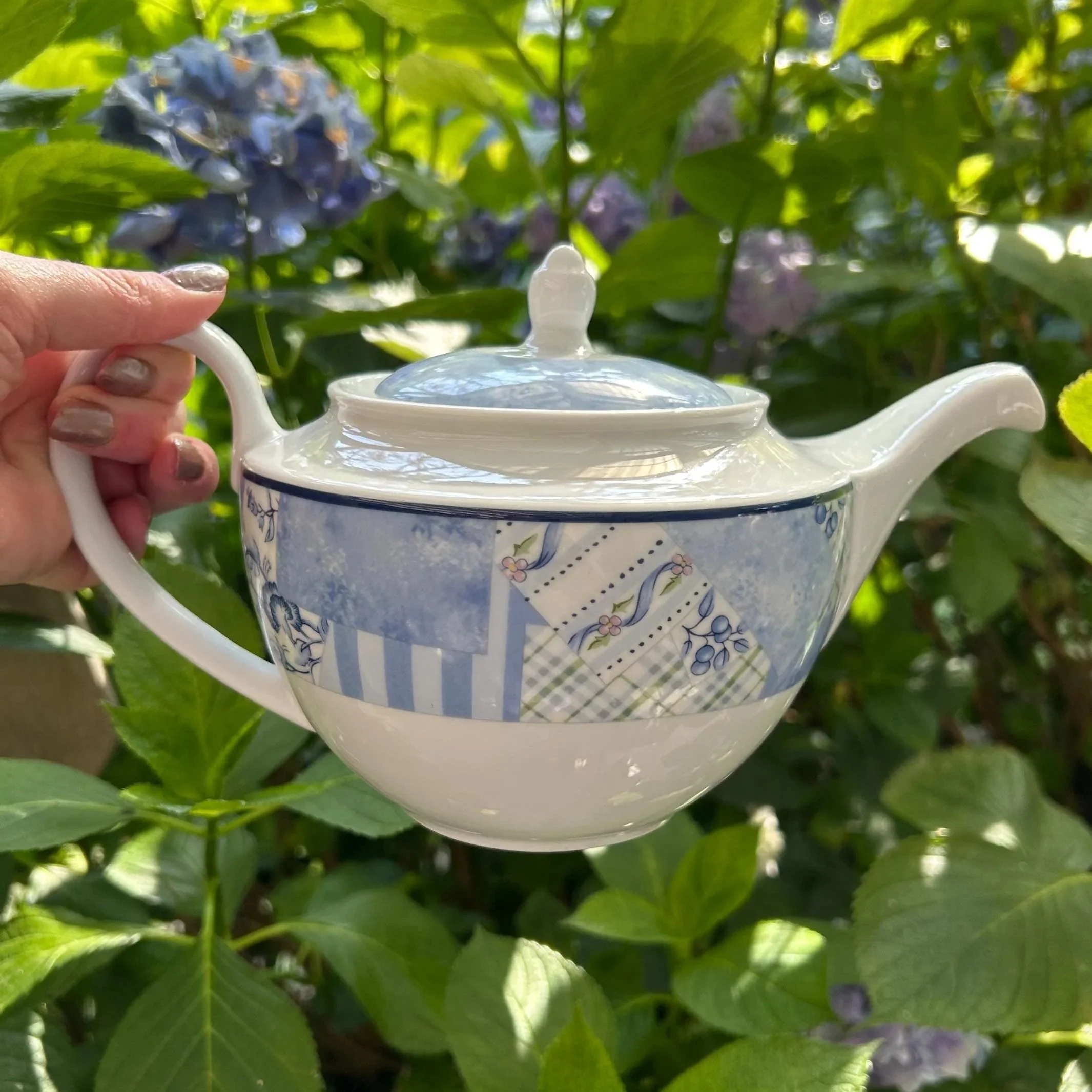 Side view of the Wedgwood Indigo teapot showing the curved handle, lid and blue patchwork pattern