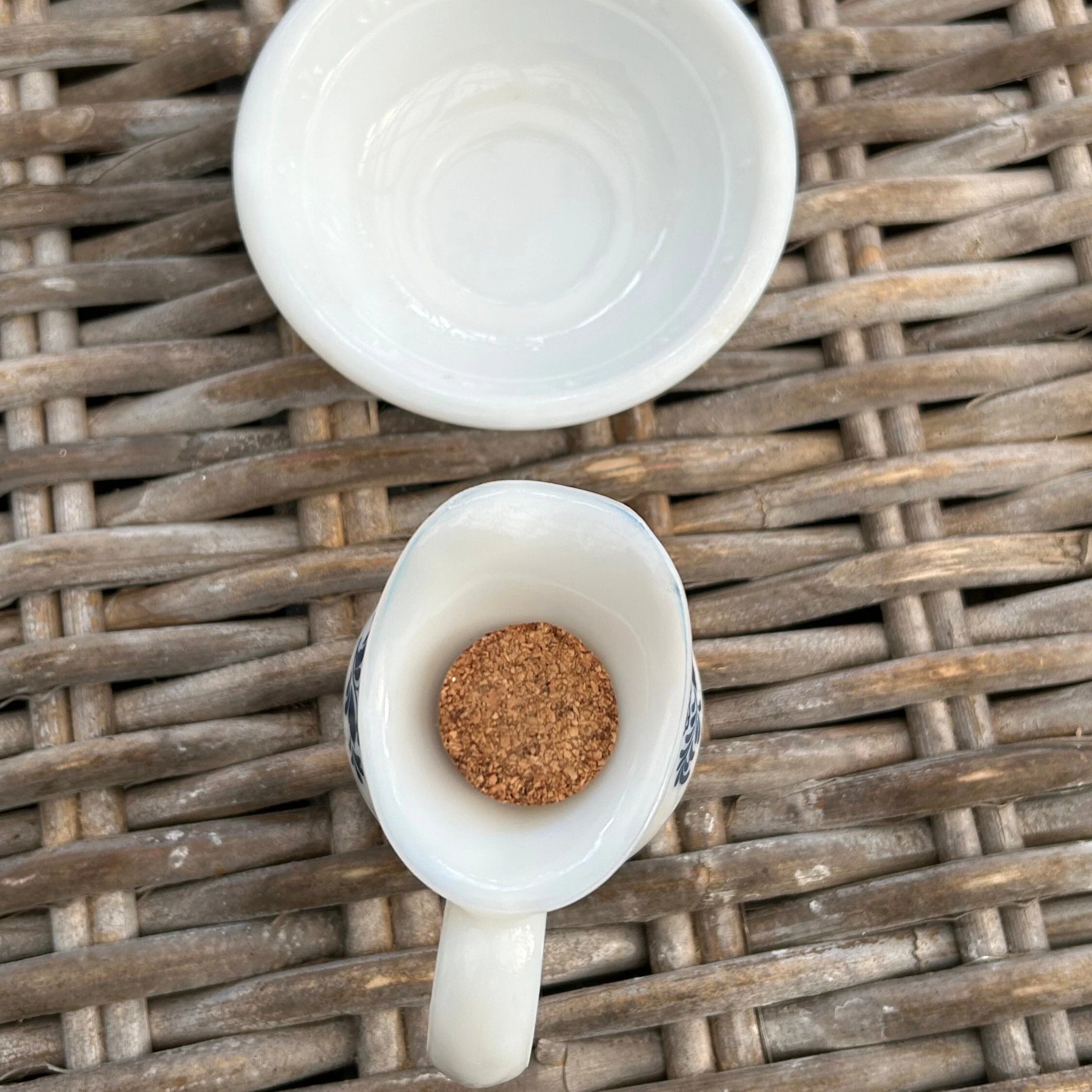 Overhead of bowl and pitcher with cork lid inside