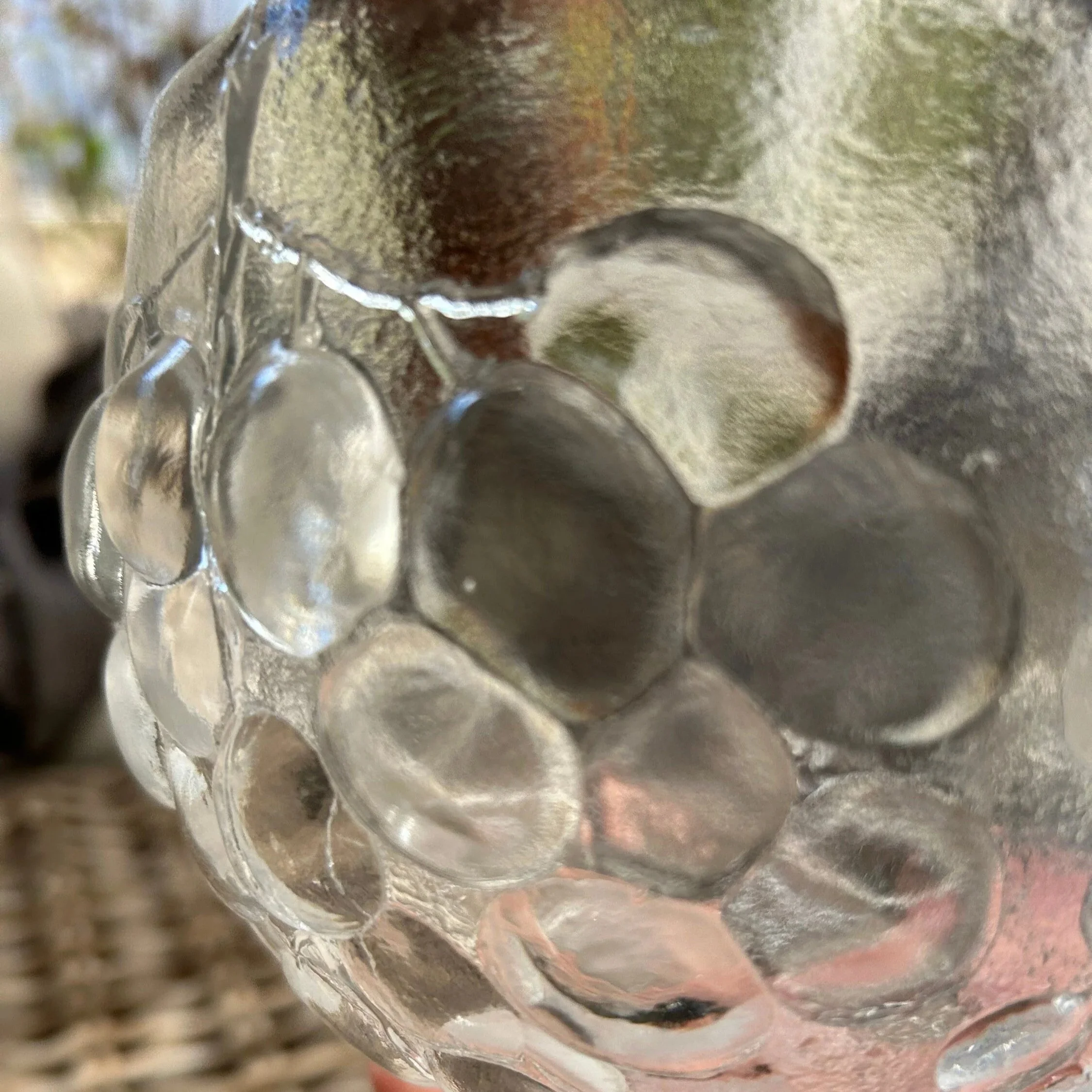 Detail view of outer grape pattern with finger for scale