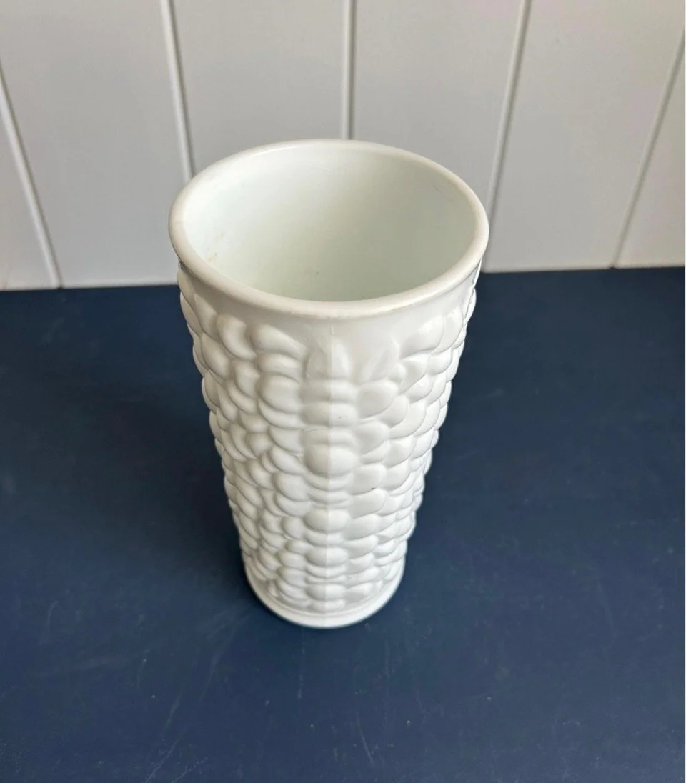 Side profile of vintage milk glass grape vase showing moulded seam and tapered cylindrical form