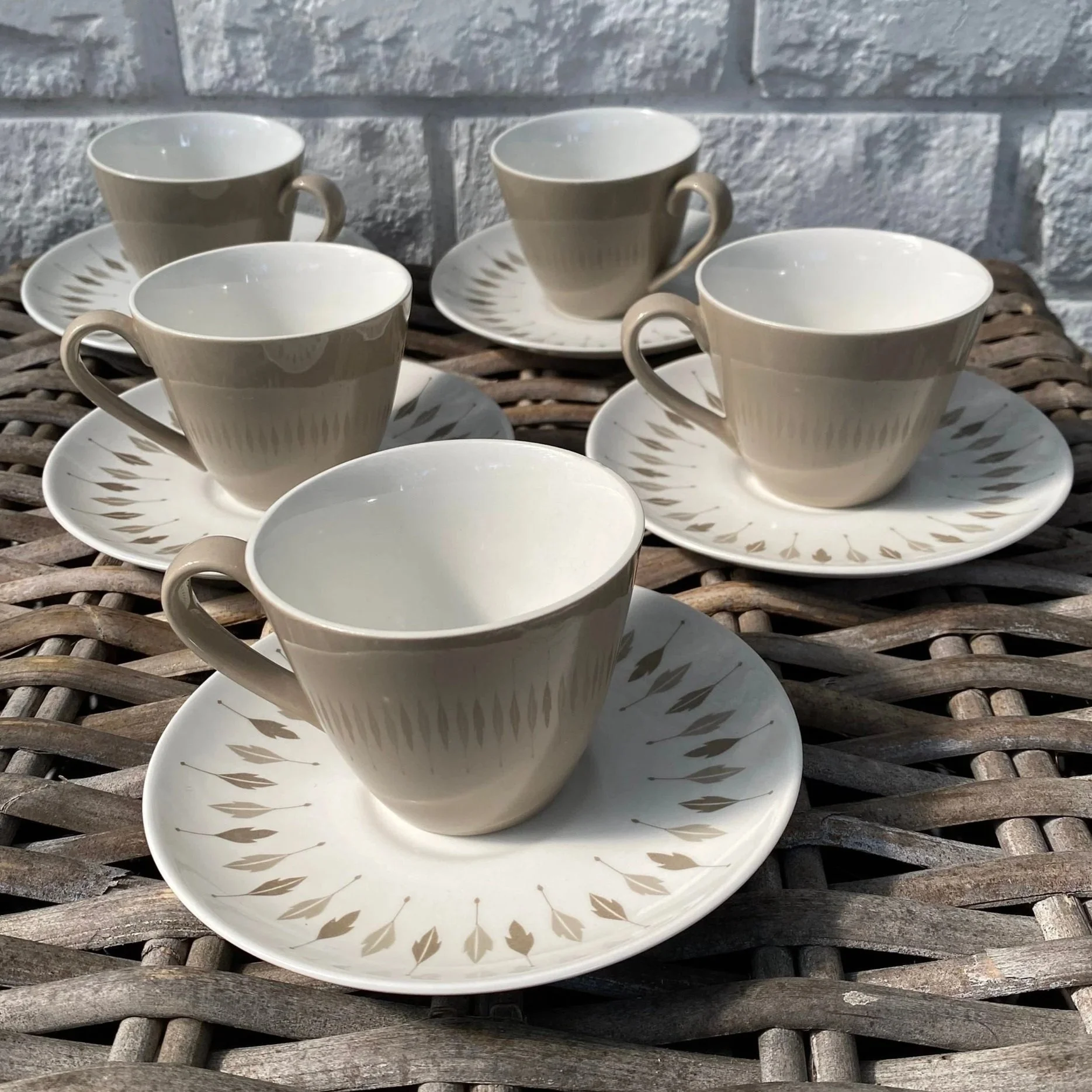 Group of 5 Johnson Bros Snowhite teacups and saucers on wicker surface