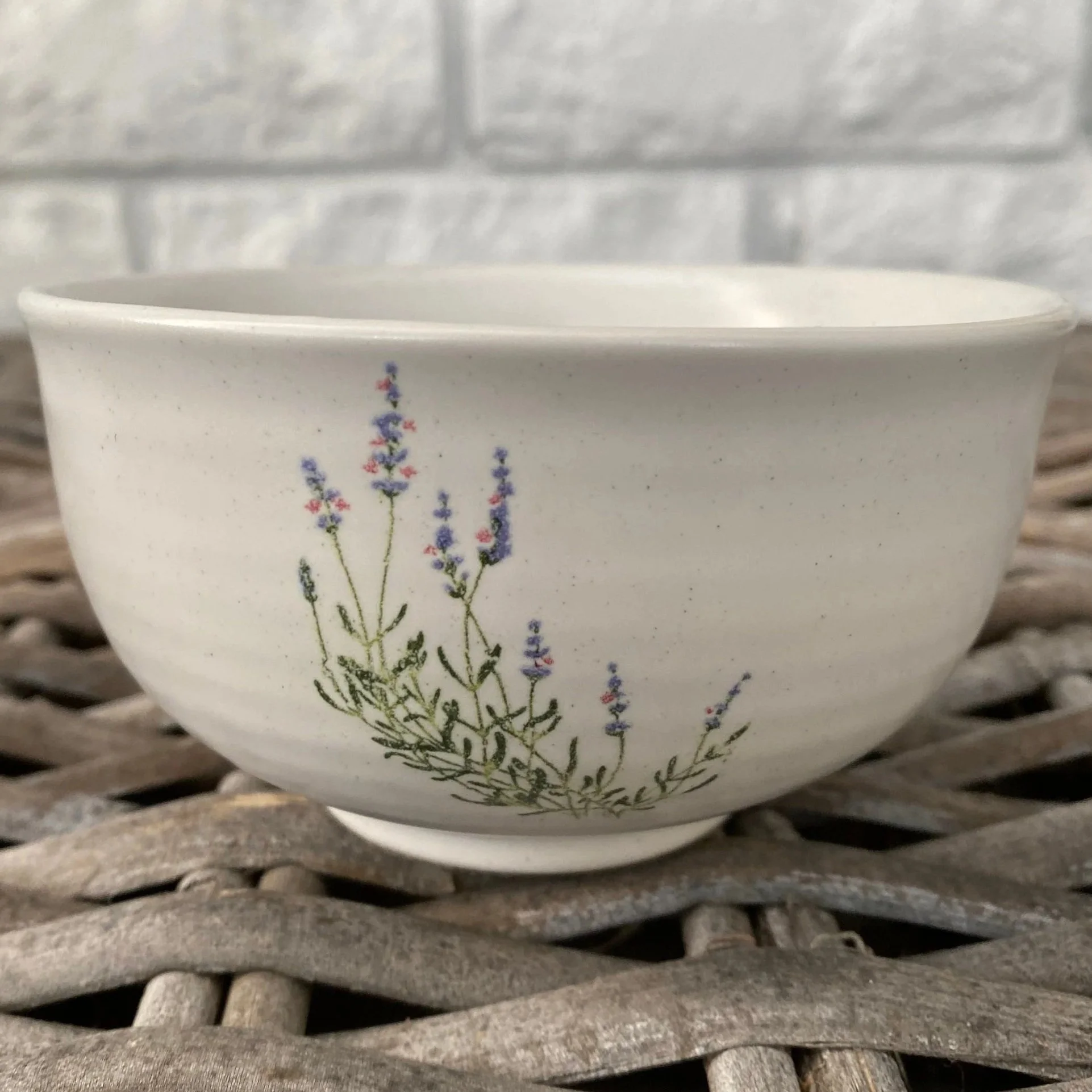 Close-up of the ceramic bowl showing the lavender floral detail and rounded shape