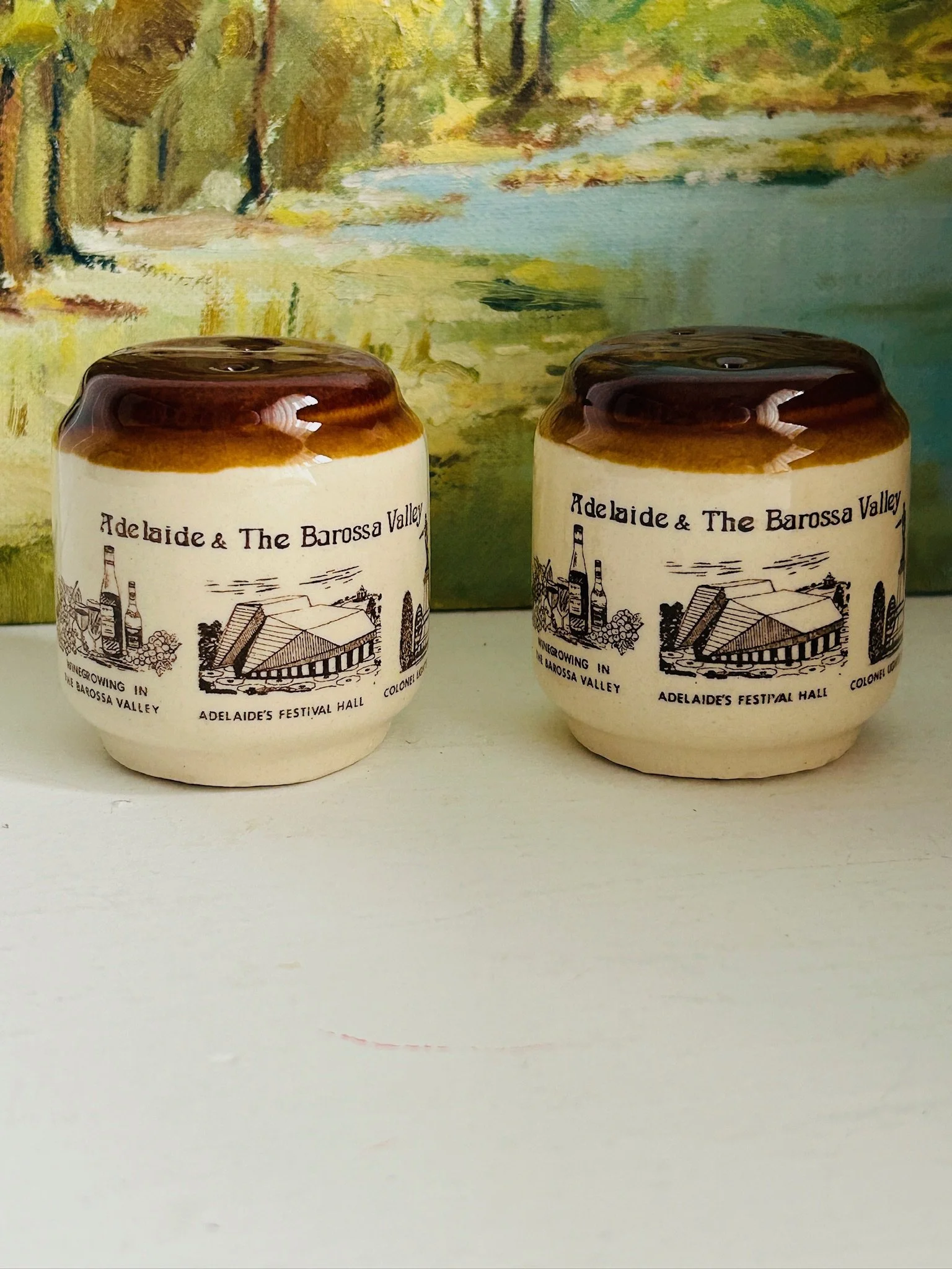 Front view of the matching shaker set displayed side by side, showing the retro Australian landmark graphics and warm brown glazed tops.