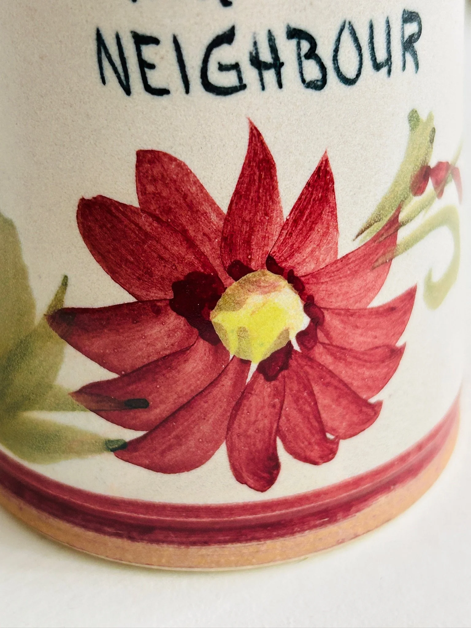 Close-up of the hand-painted burgundy flower and lower section of the vase