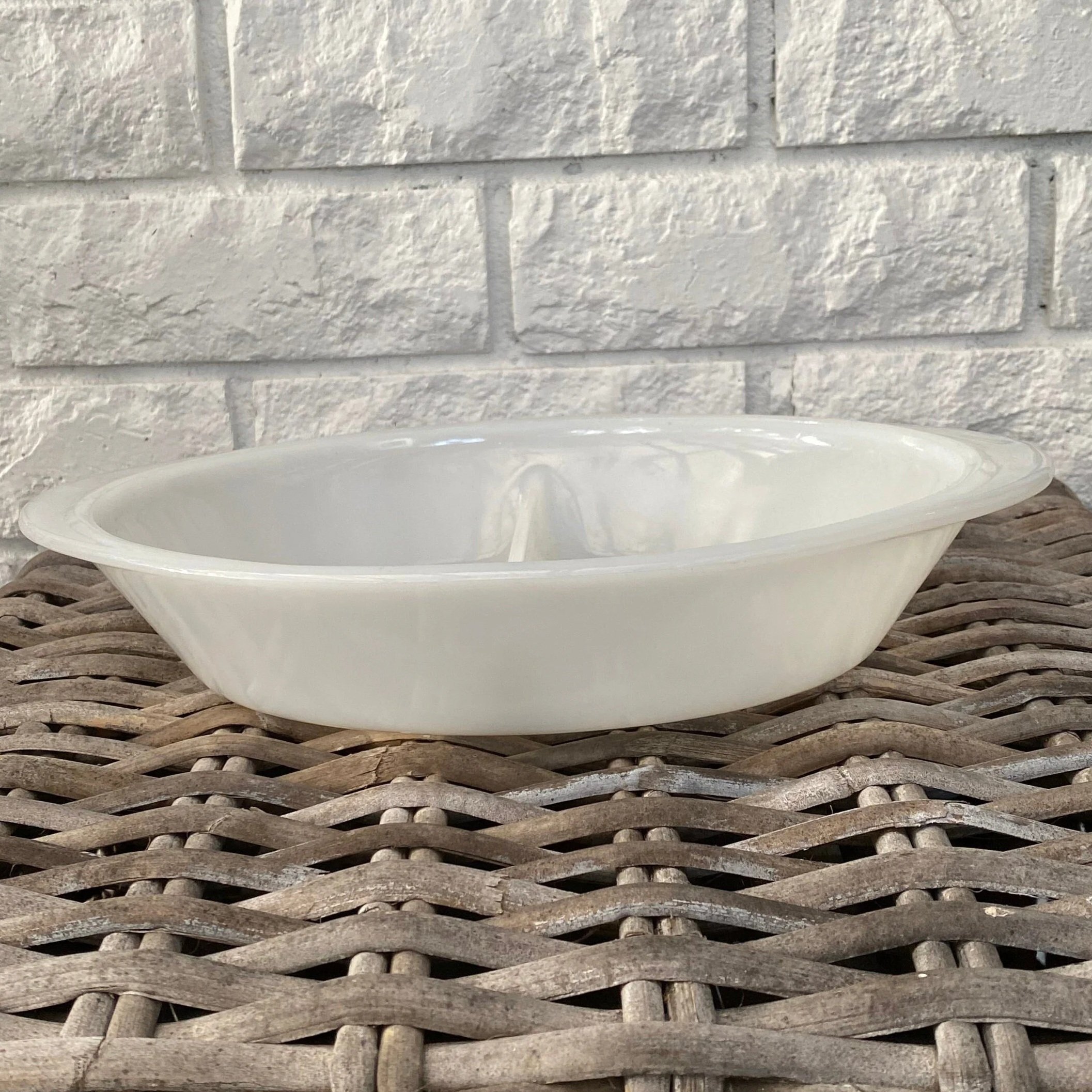 Side profile of GlasBake divided dish against a white brick background