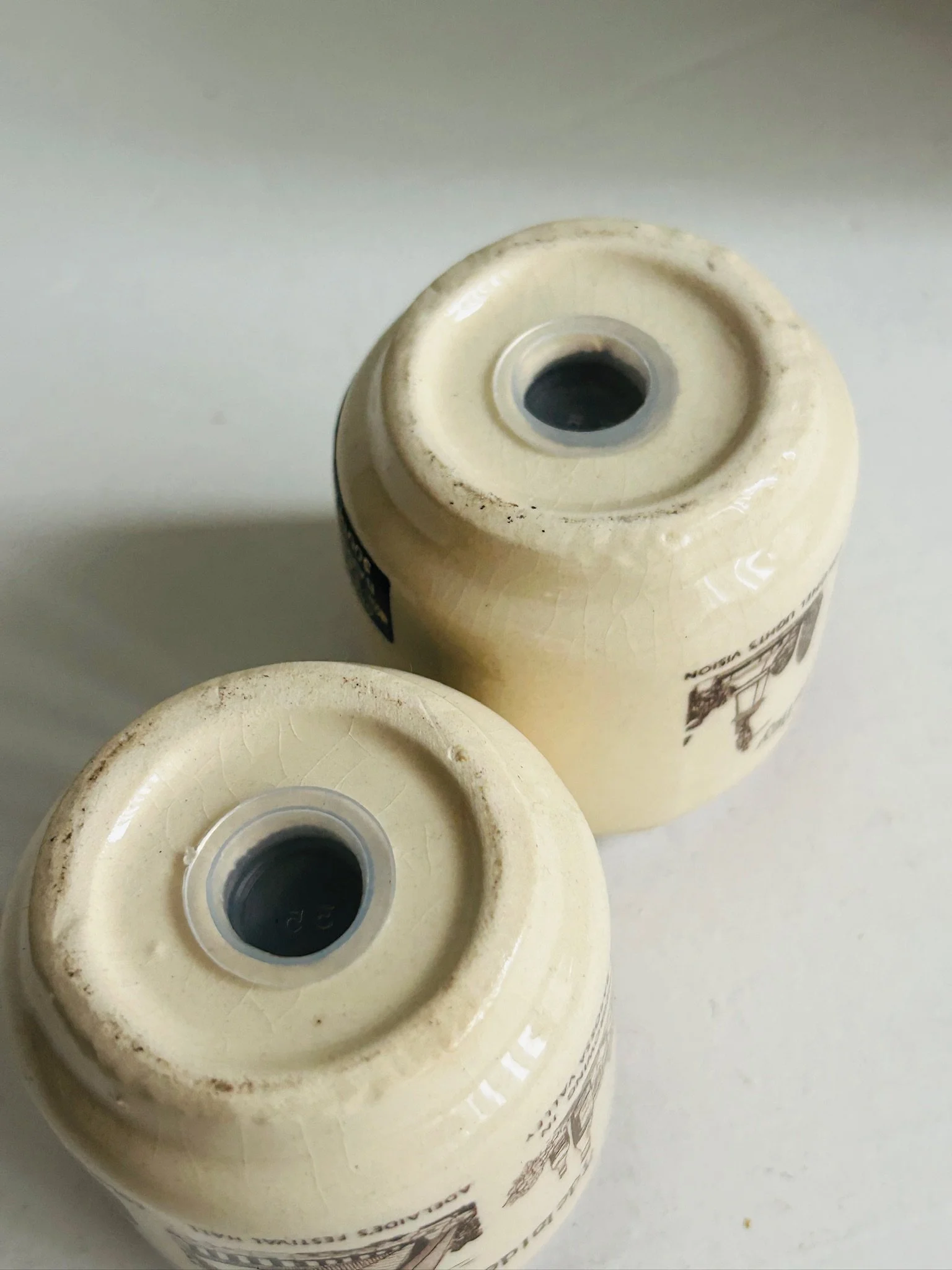 Underside view of both shakers showing the fill holes in the bases and unglazed base rims.