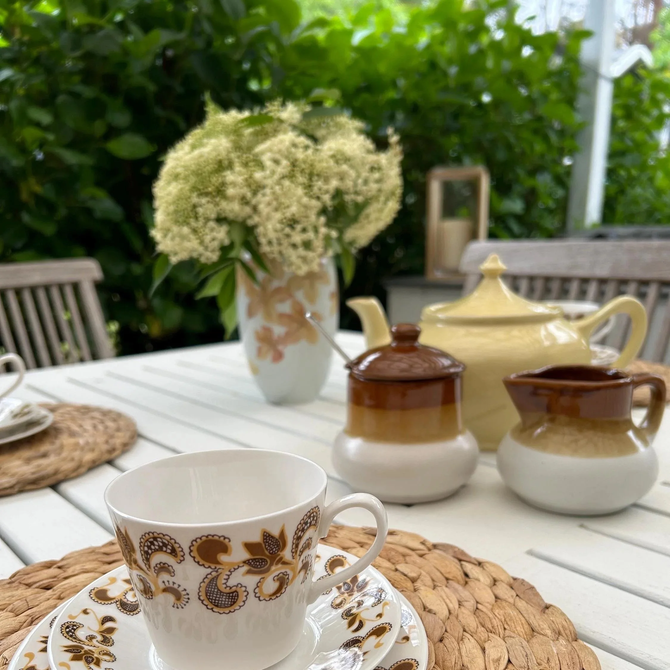 Styled table scene with matching vintage ceramics and the vase in the background