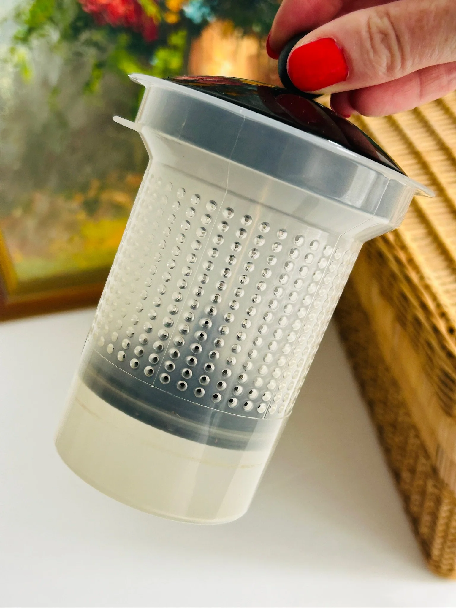 Infuser insert removed from the teapot, showing the white perforated mesh cylinder and plastic rim detail.