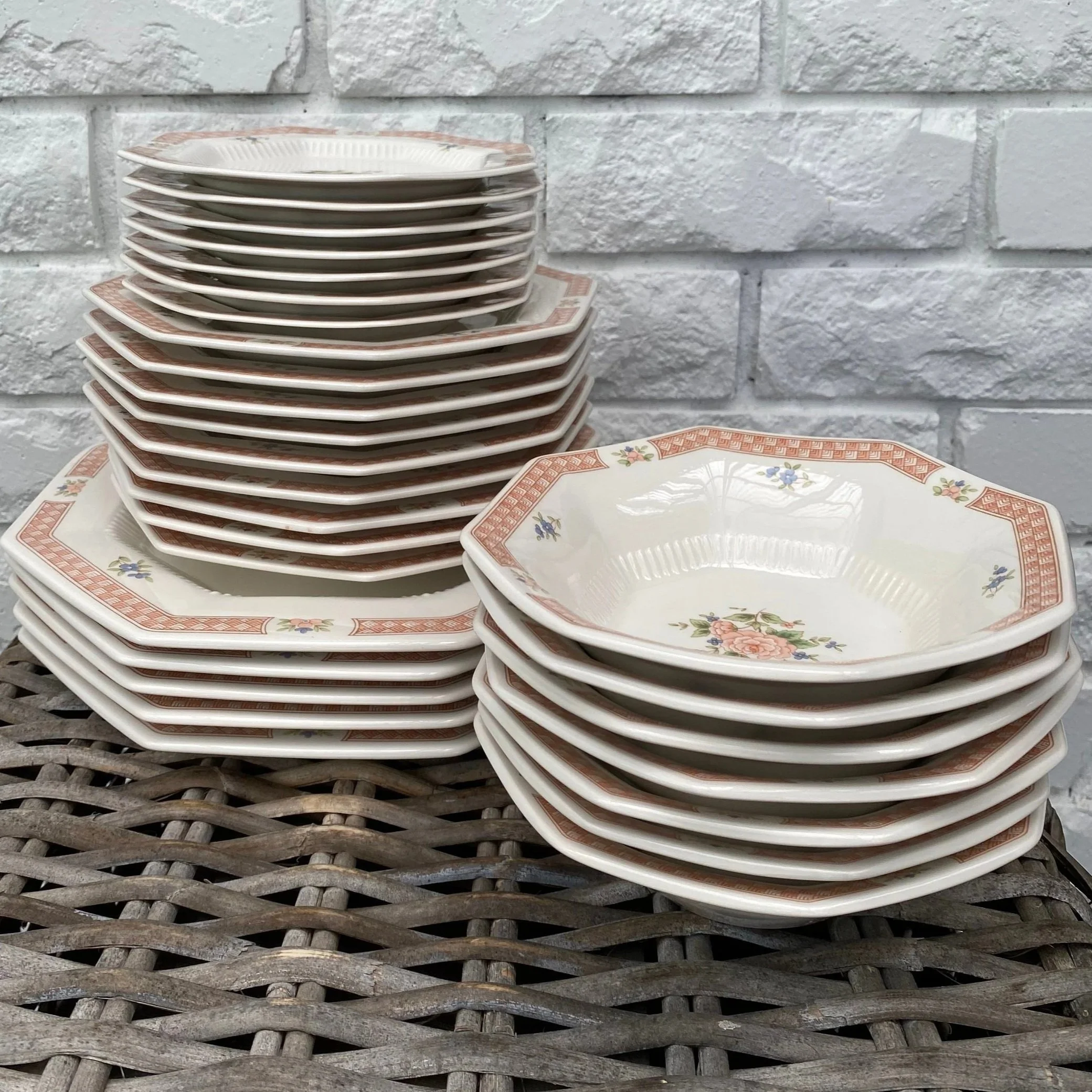 Full set of Nikko Cameo Rose dinnerware stacked – plates and bowls with floral motif and peach border