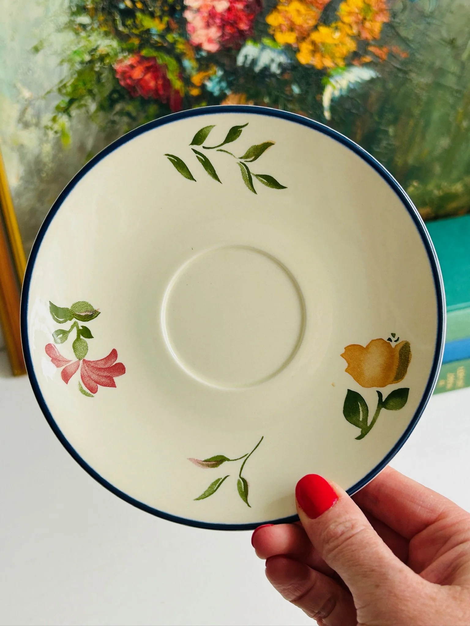 Overhead view of the matching Staffordshire ‘Calypso’ saucer, featuring scattered floral motifs and a dark blue rim.