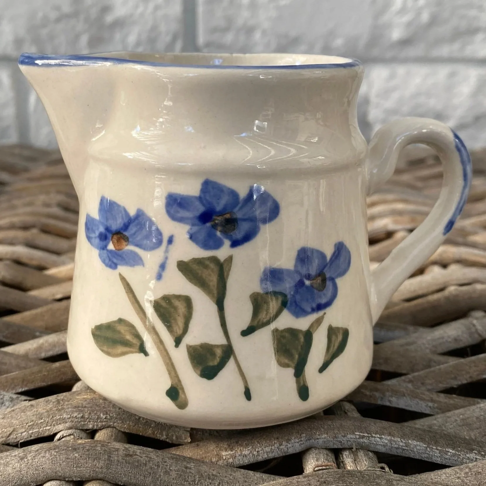 Side profile of milk jug showing painterly glaze and petal details