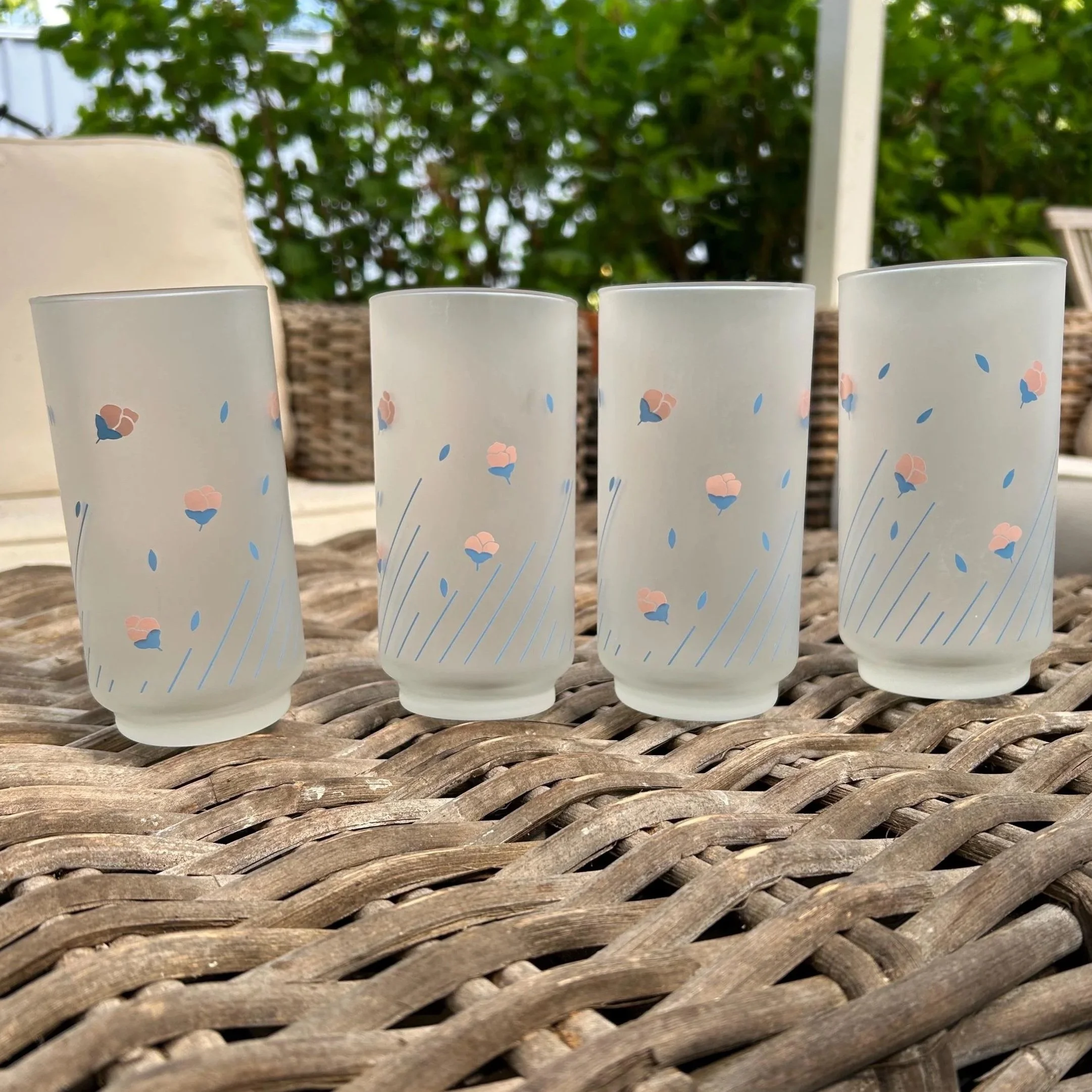 Full set of four 1980s floral frosted glasses lined up outdoors