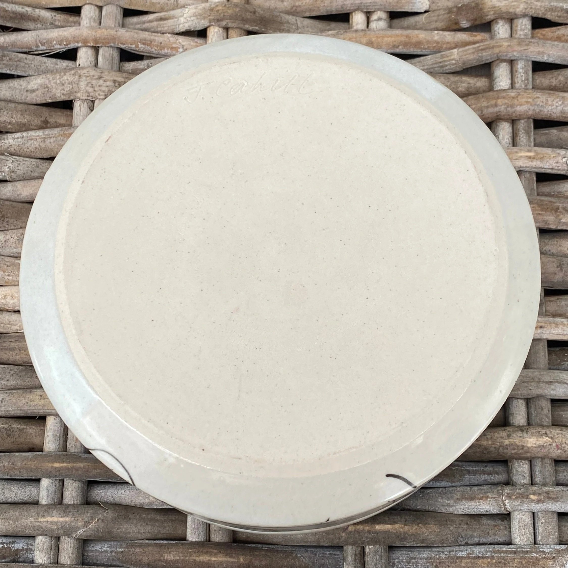 Base of bowl showing smooth unglazed clay and artist's signature