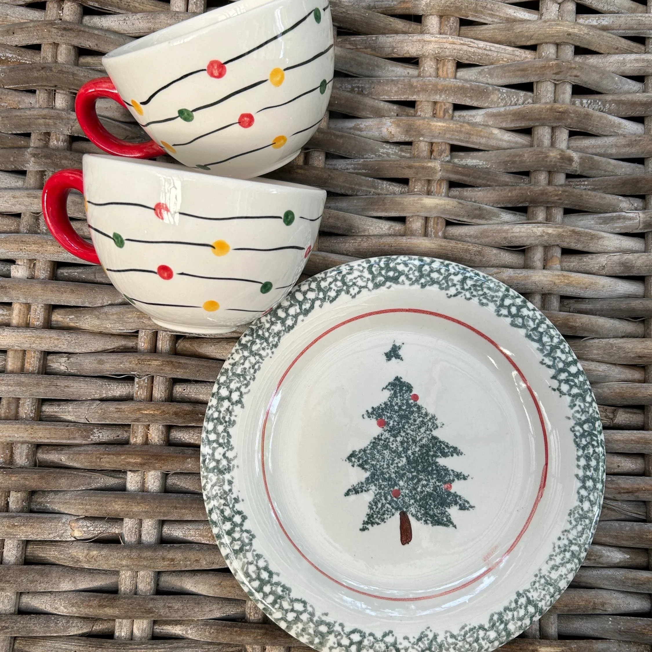 Vintage Christmas tableware set featuring 2 holiday lights mugs and 1 Newcor 'Greenery' side plate with a Christmas tree motif.