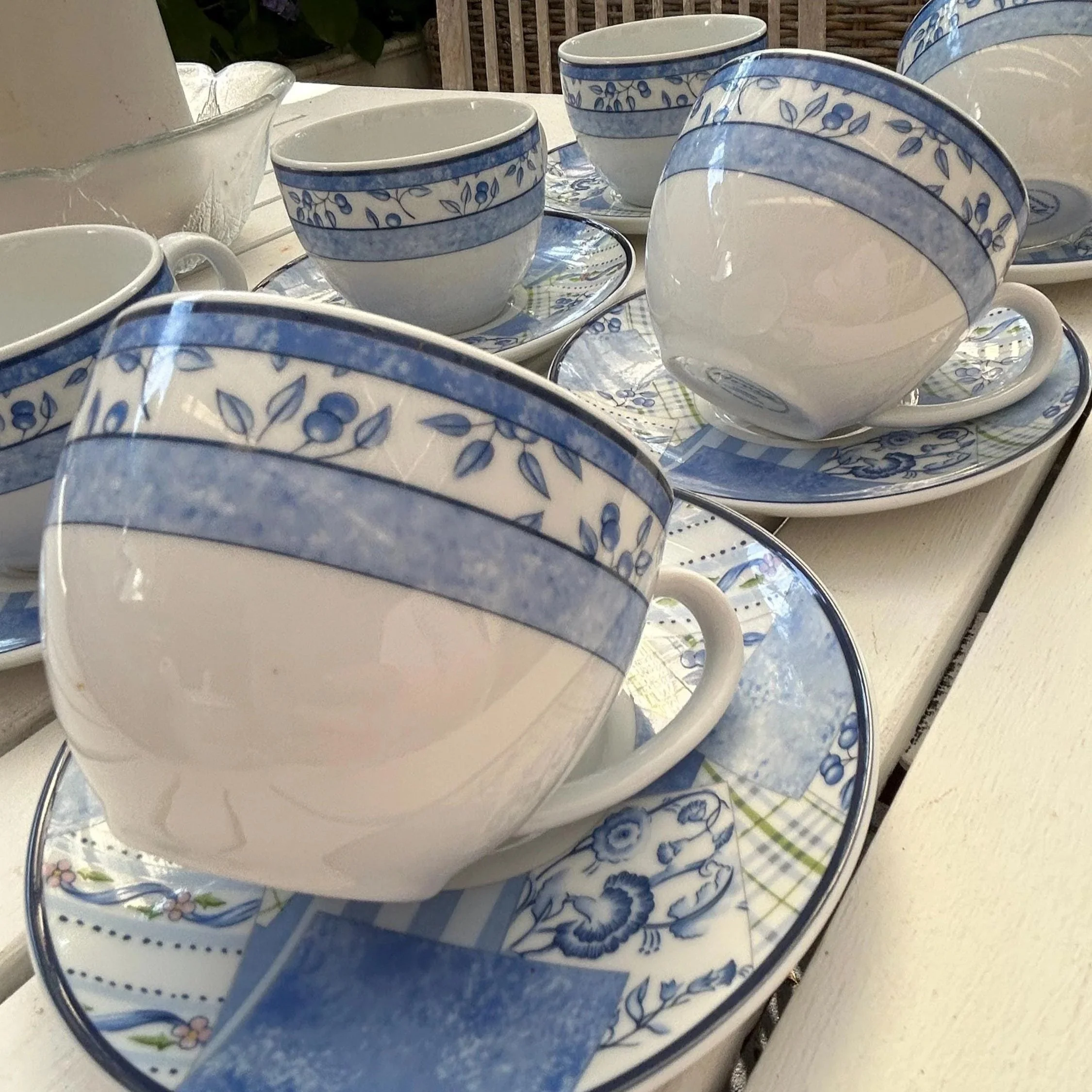 Side view of a teacup and saucer highlighting the rounded cup shape and blue border detail
