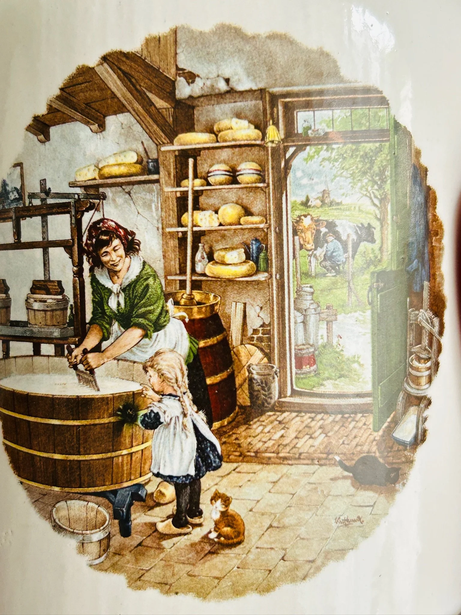 Close-up of the interior cheese shop scene painted on one ceramic pot, showing shelves of cheeses, a woman at work, and a child in the doorway.