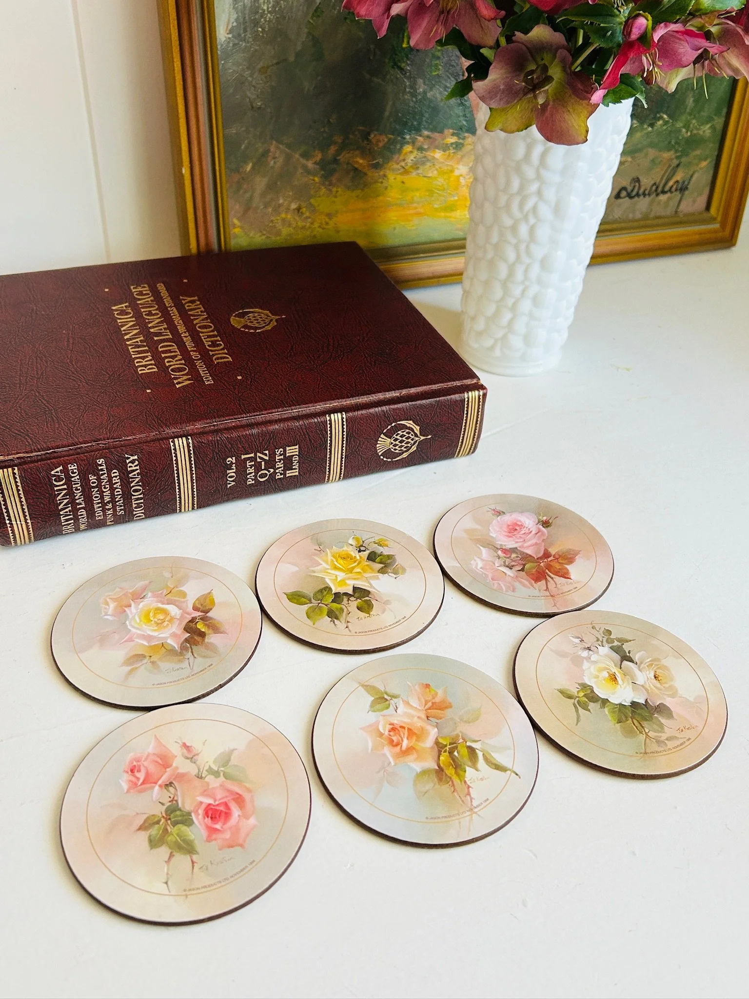 Six Jill Kirstein rose coasters laid out showing all six designs, cork backed and edged in gold