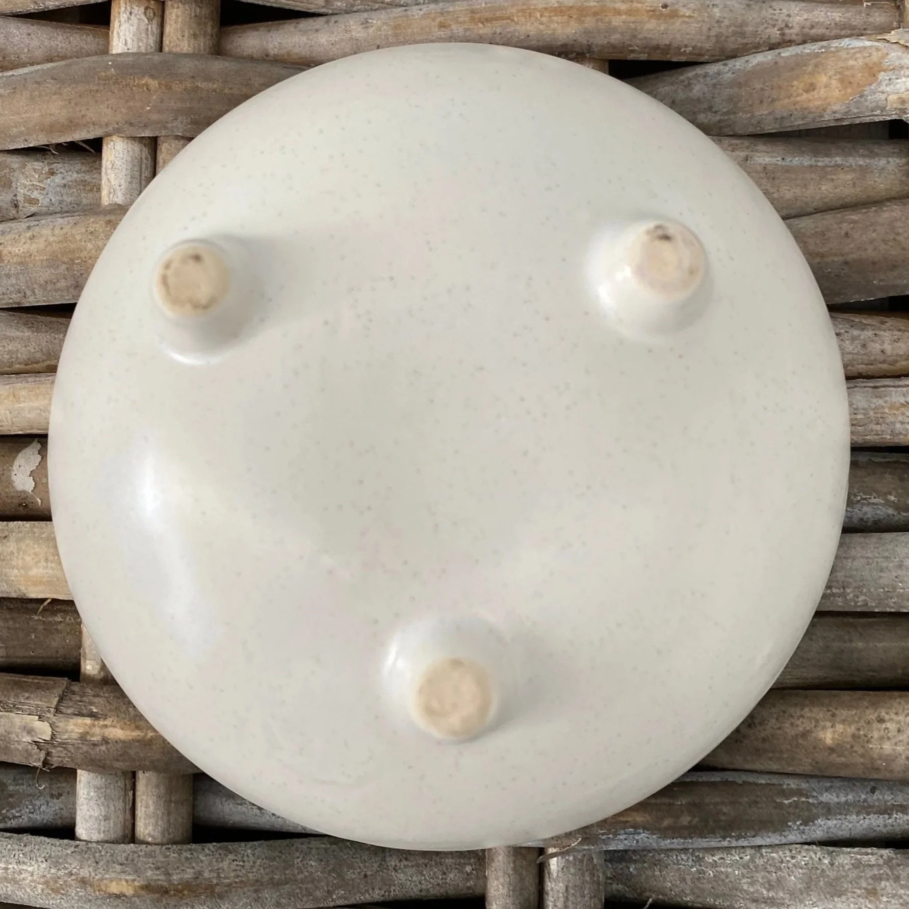 Underside of the soap dish showing the three small feet and speckled ceramic finish