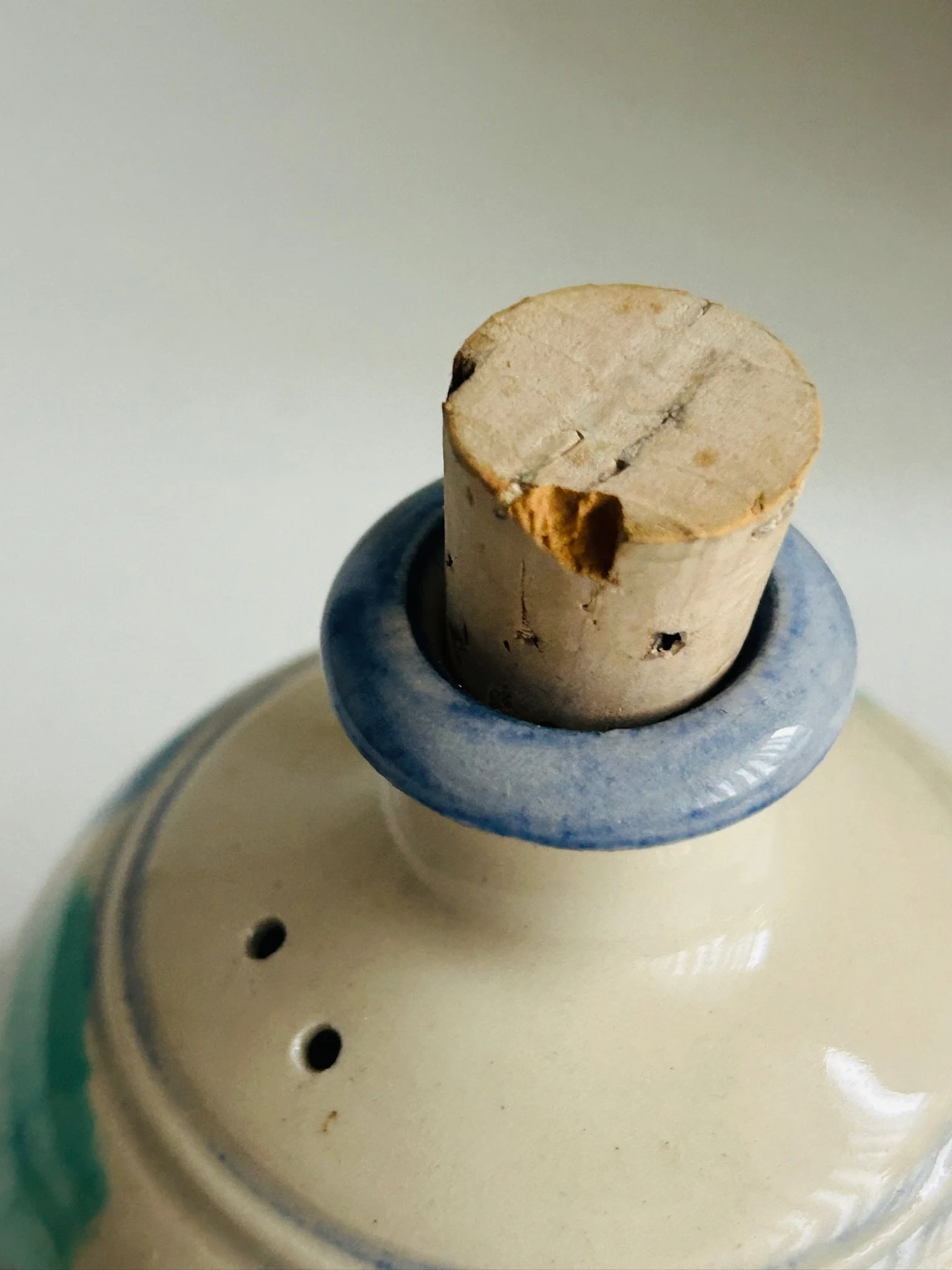 Close-up of cork stopper seated in blue-glazed collar at the top of the shaker