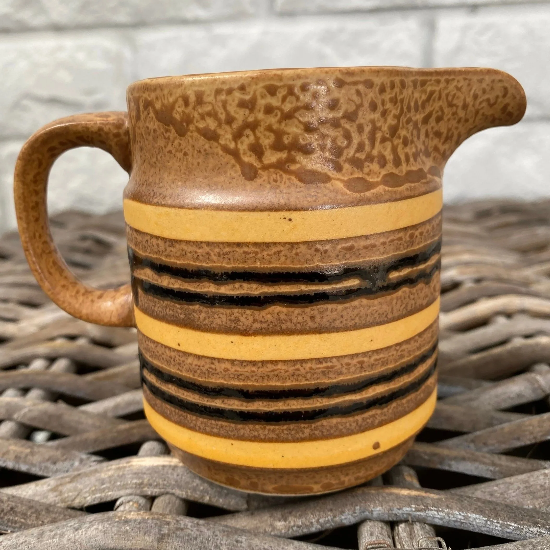 Creamer jug with visible hand-painted banding and rich glaze