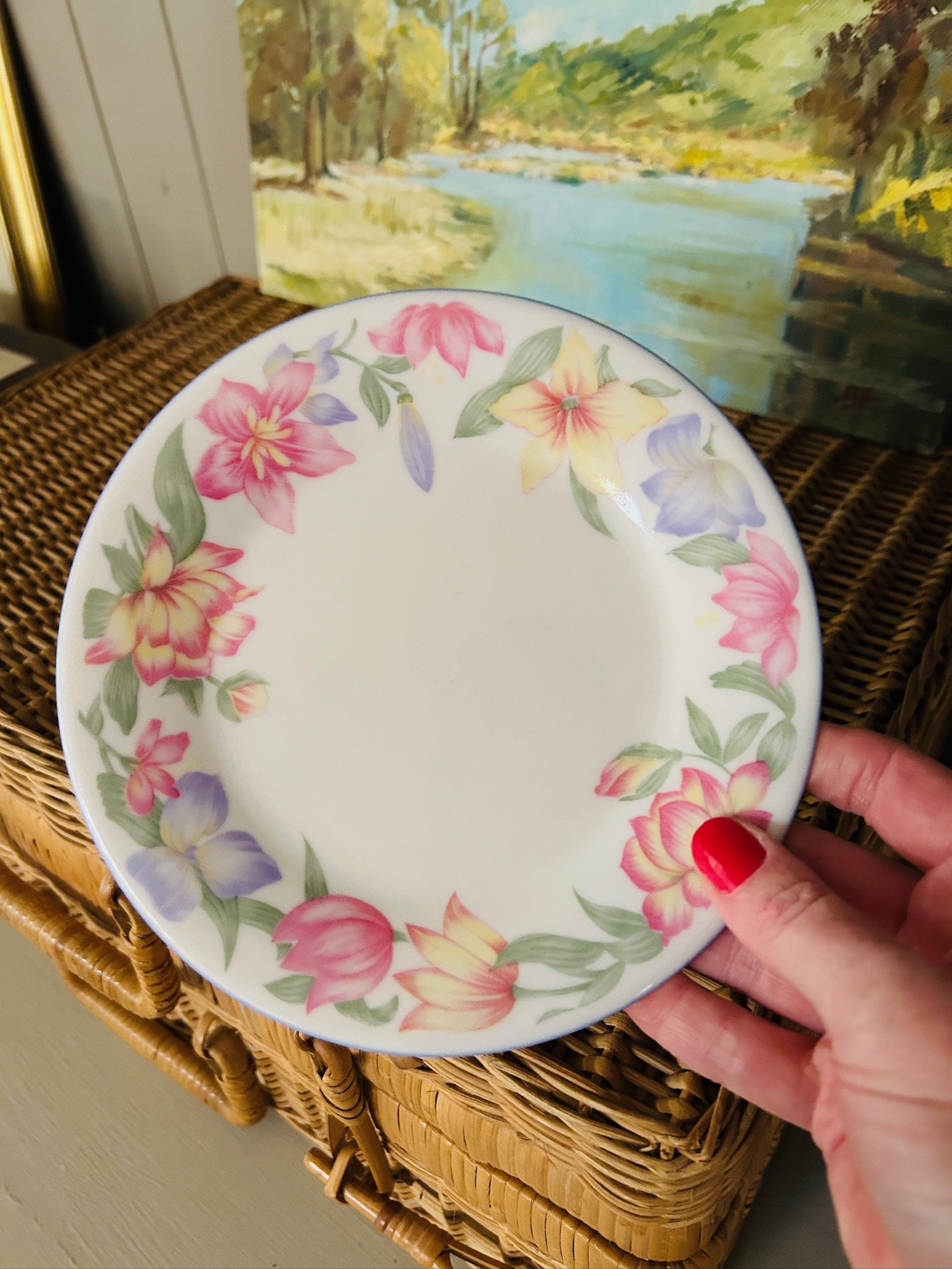 Single Royal Doulton Blooms side plate held in hand, showing the full floral border in pink, yellow, and purple with the soft blue-lavender rim
