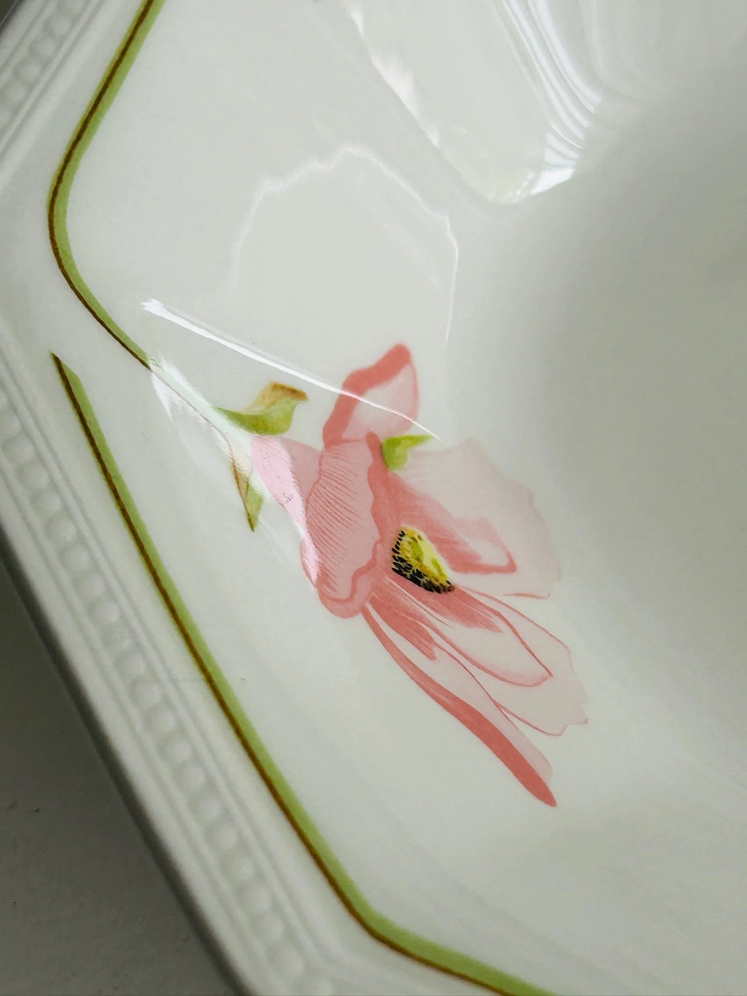 Detail of a single pink flower and green stem inside the bowl, showing the soft Spring Morning floral pattern.