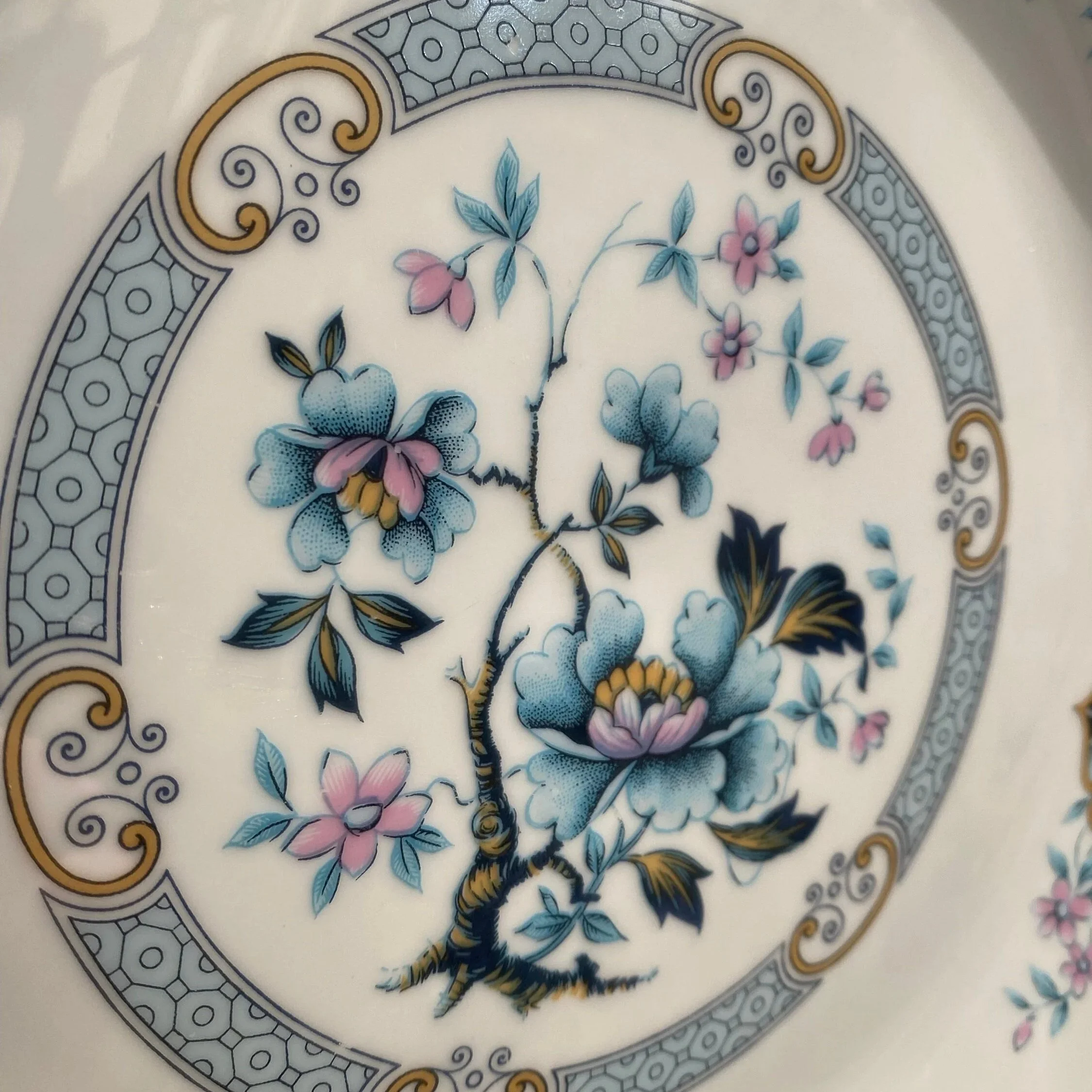 Close-up of the centre floral motif with blue flowers, pastel accents, and decorative border detail
