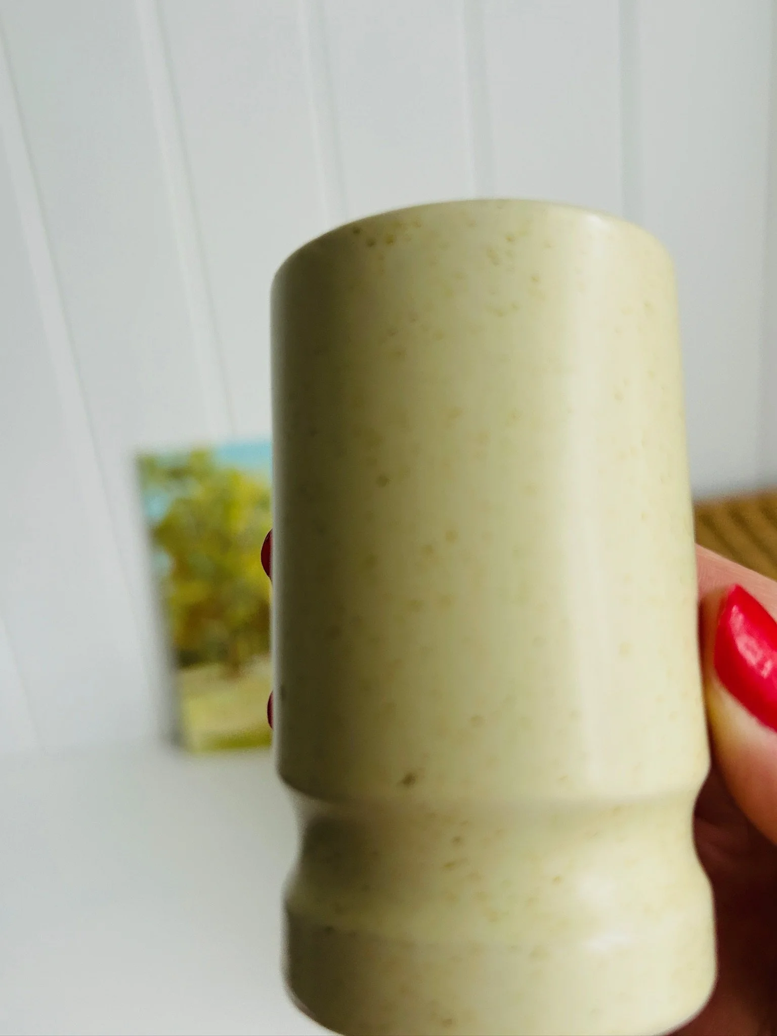 Close side view of one shaker held in hand, highlighting the plain unpatterned body and matte sheen