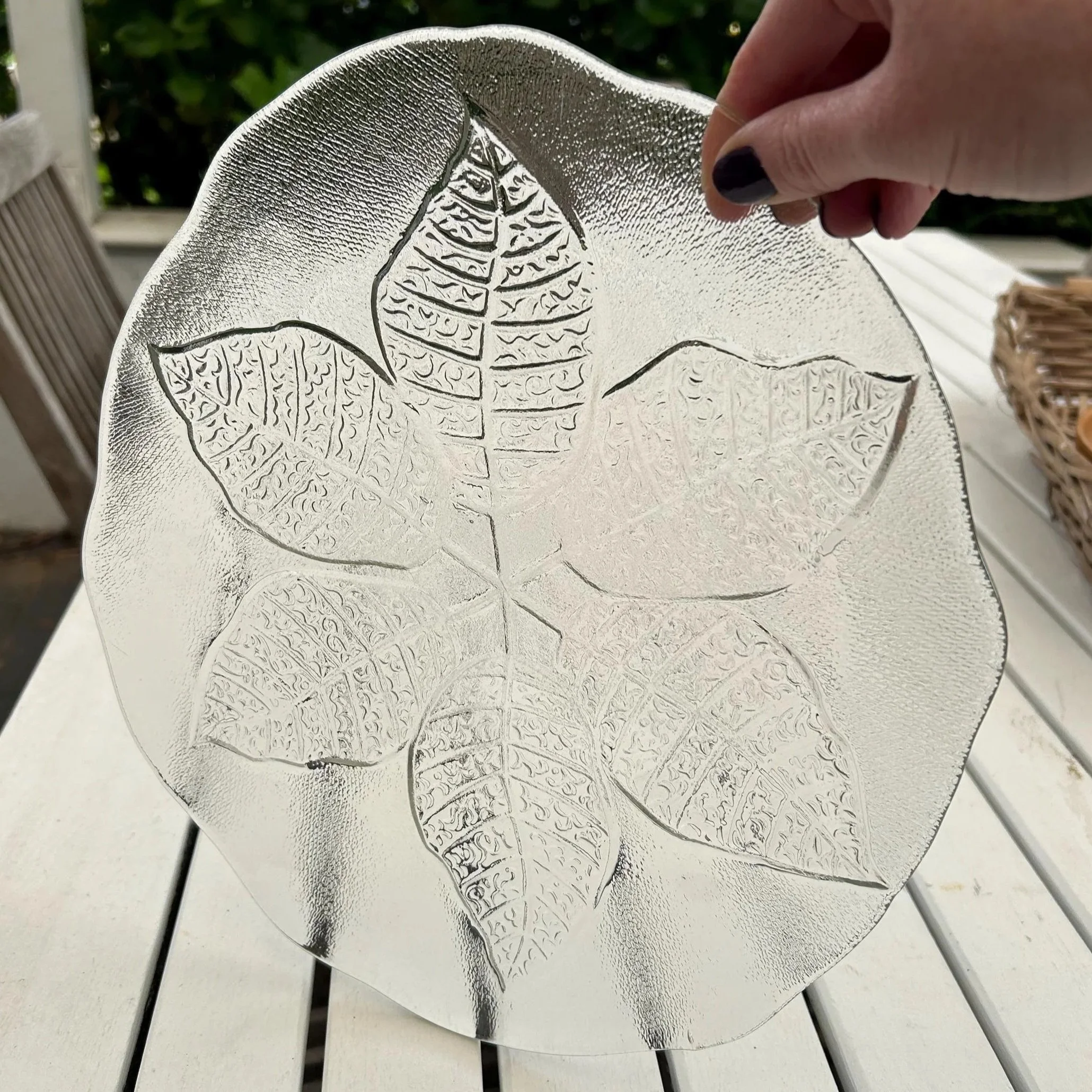 Plate displayed flat on white table, showing symmetrical leaf motif