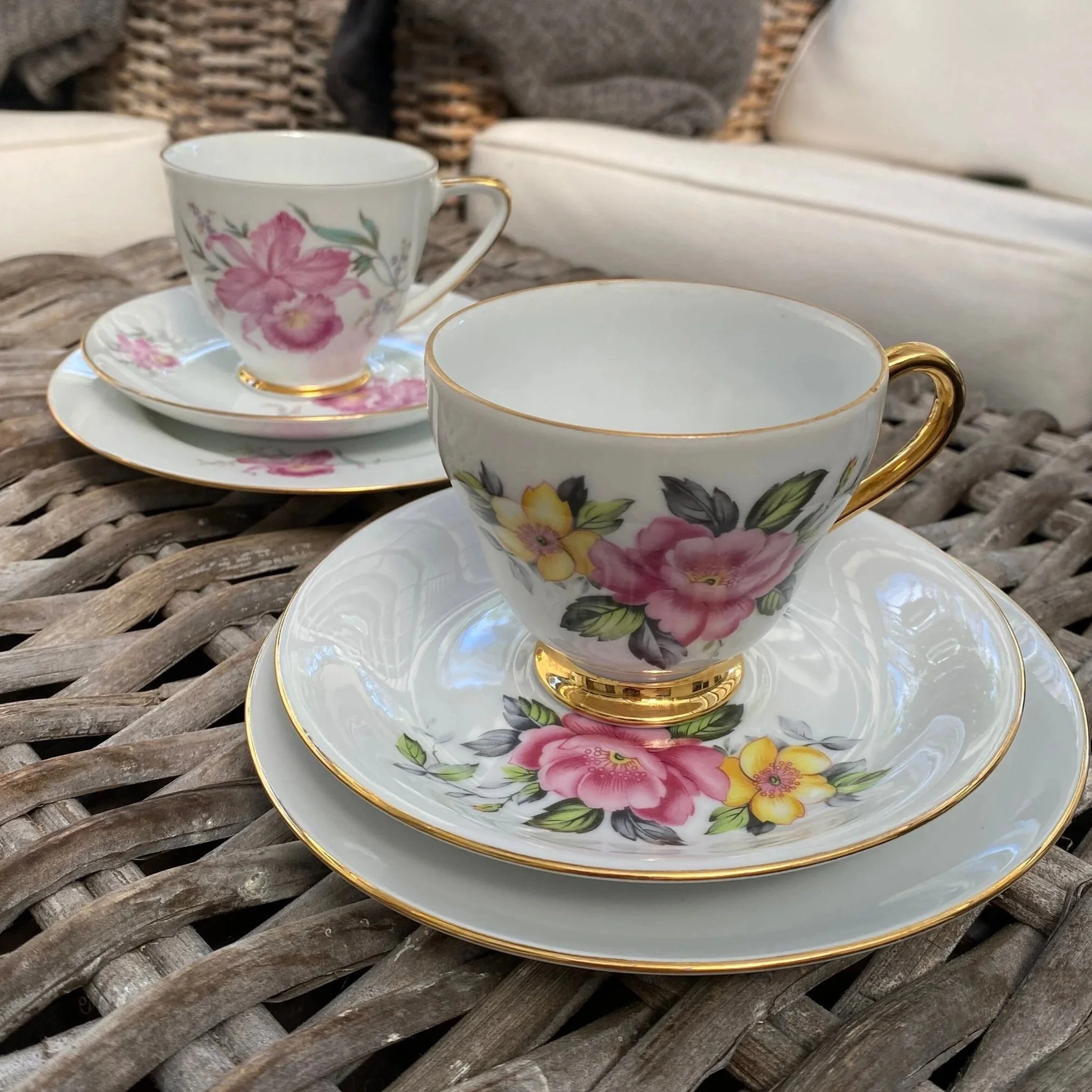 Two Westminster floral tea trios stacked together, showing teacups, saucers and side plates with gold trim