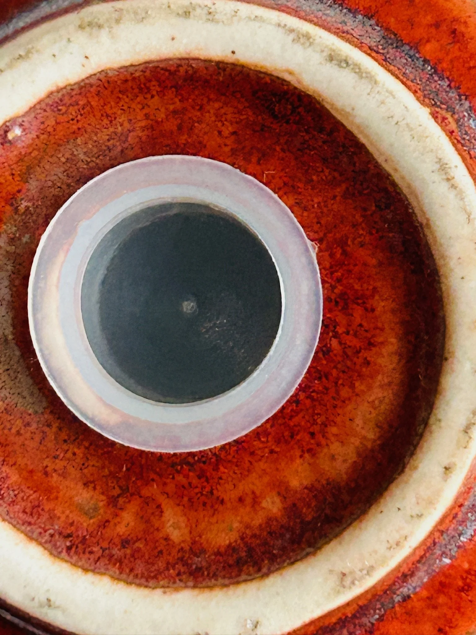 Underside of one ceramic shaker showing the glazed base and stopper opening.